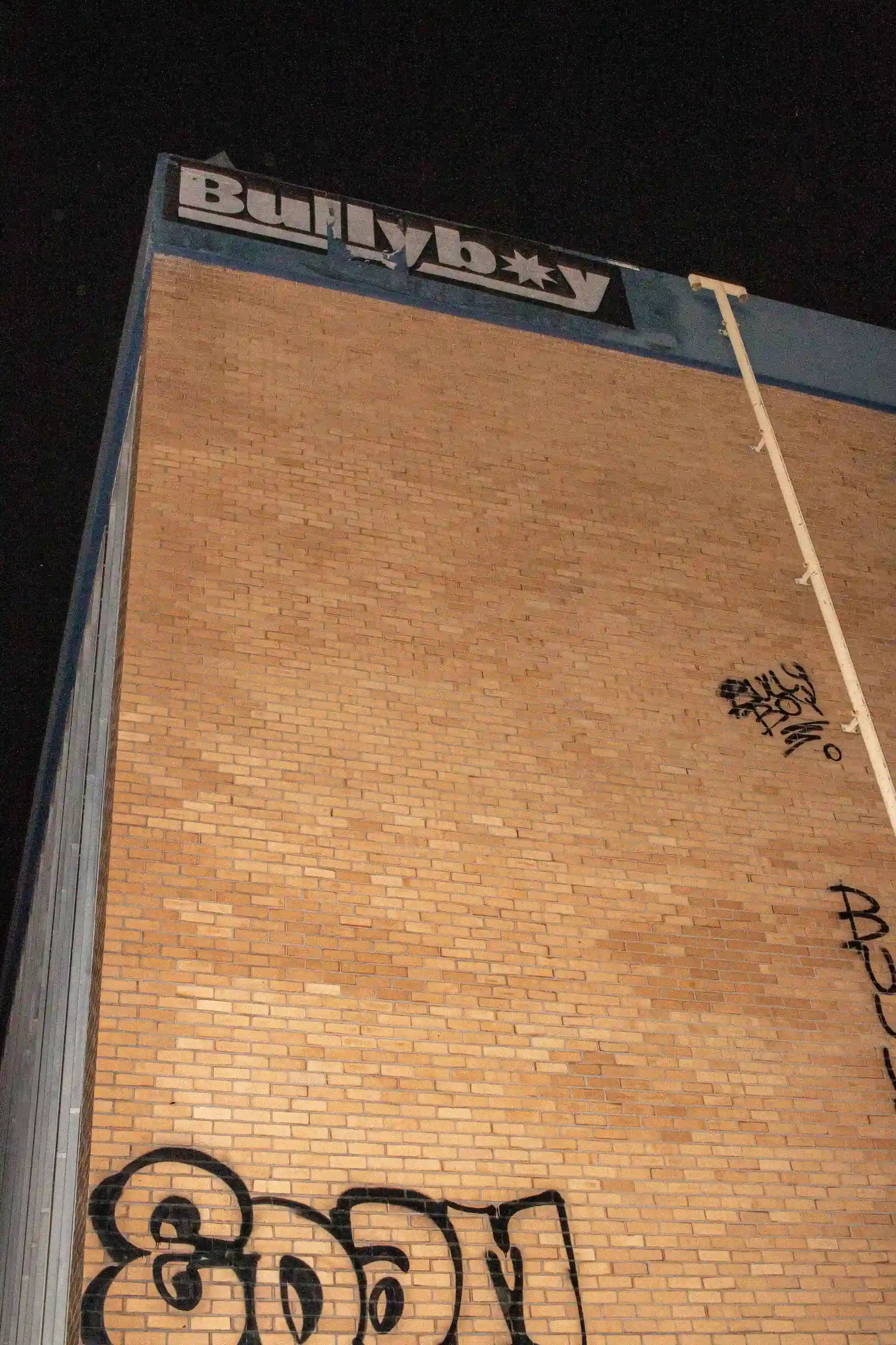 A vibrant building adorned with graffiti, featuring a fire hydrant, showcasing Bullyboy streetwear and South African fashion