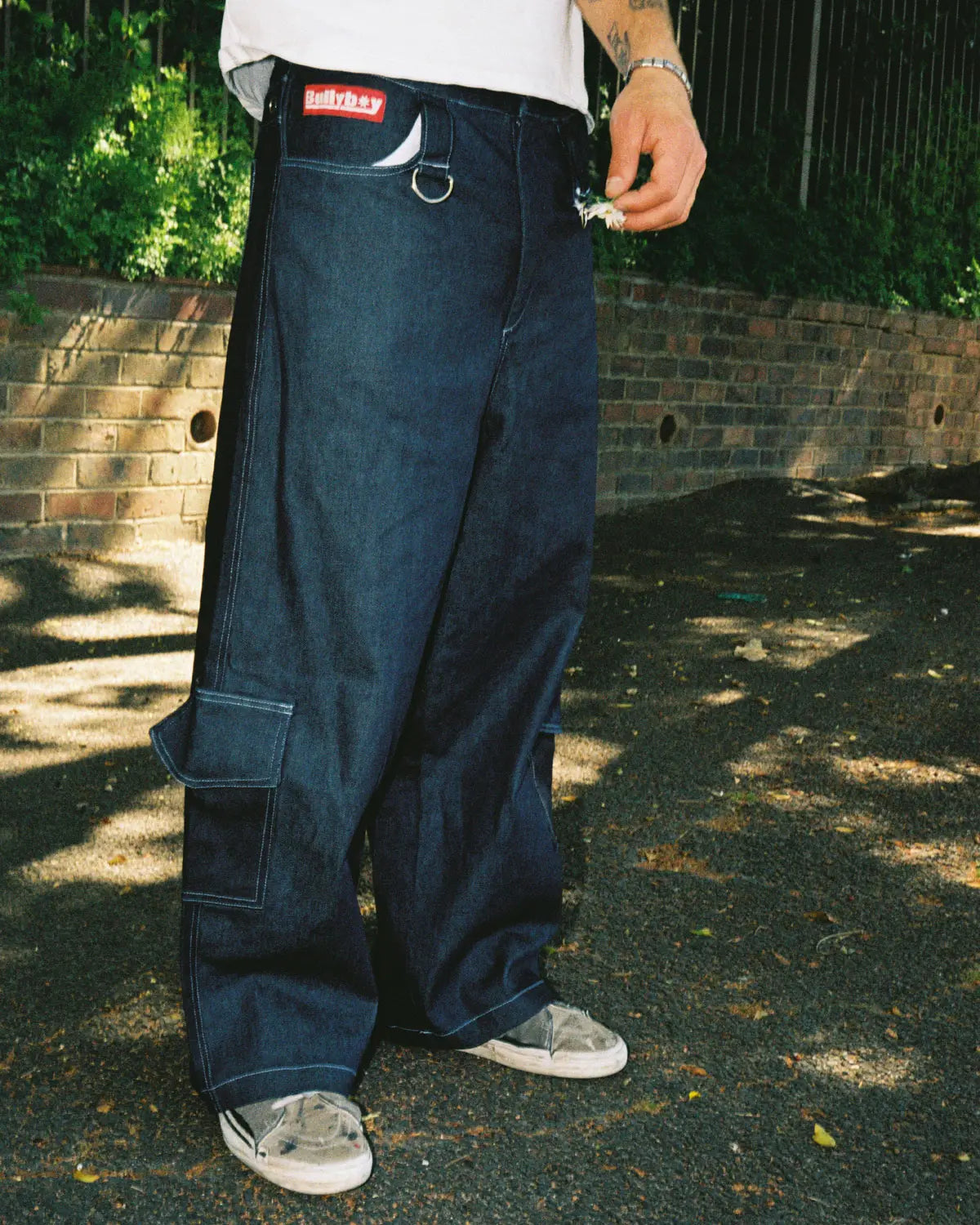 A man in a white t-shirt paired with baggy skate pants, showcasing premium streetwear style