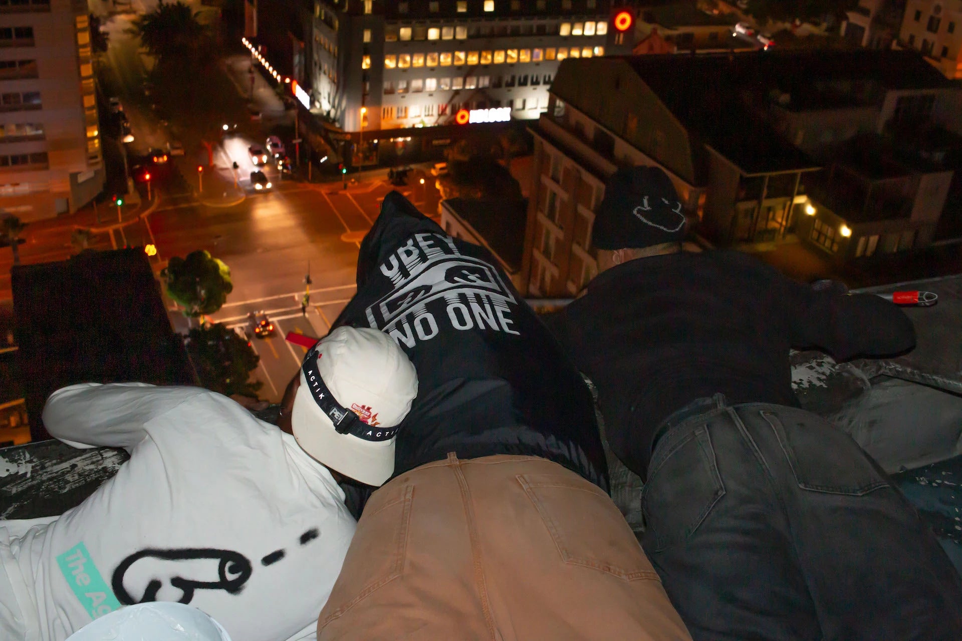 Three individuals dressed in trendy streetwear relax on a ledge, highlighting the essence of South African fashion