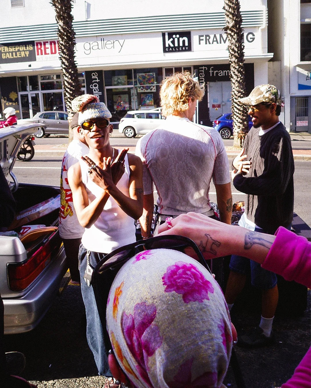 People on a street with a focus on a colorful object held by a person.