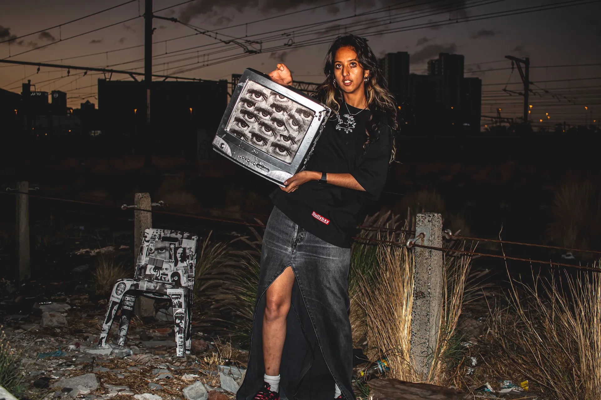 Person holding a tray with small figurines against an urban night background