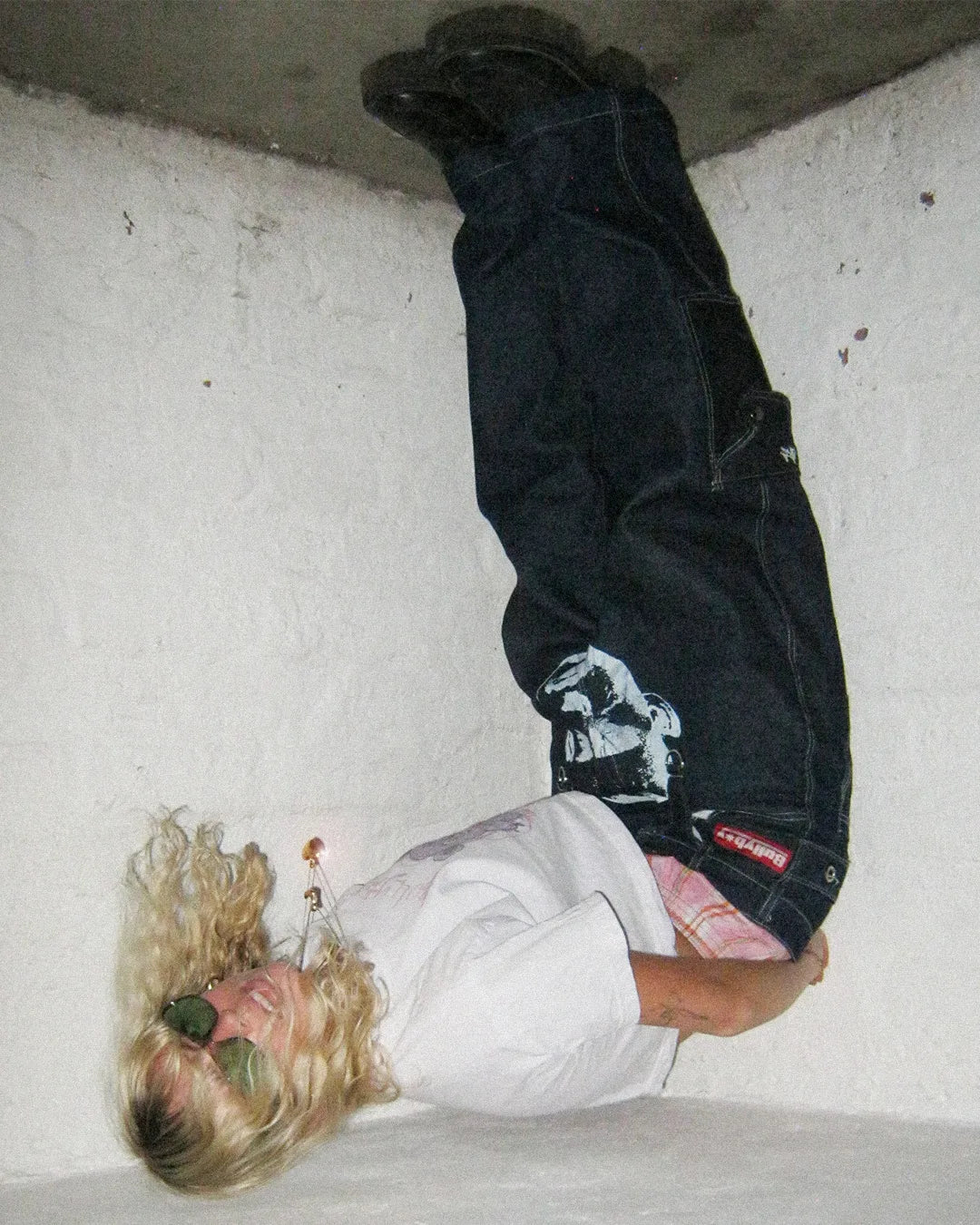 Person wearing a dark jacket with a graphic design on a light-colored floor.