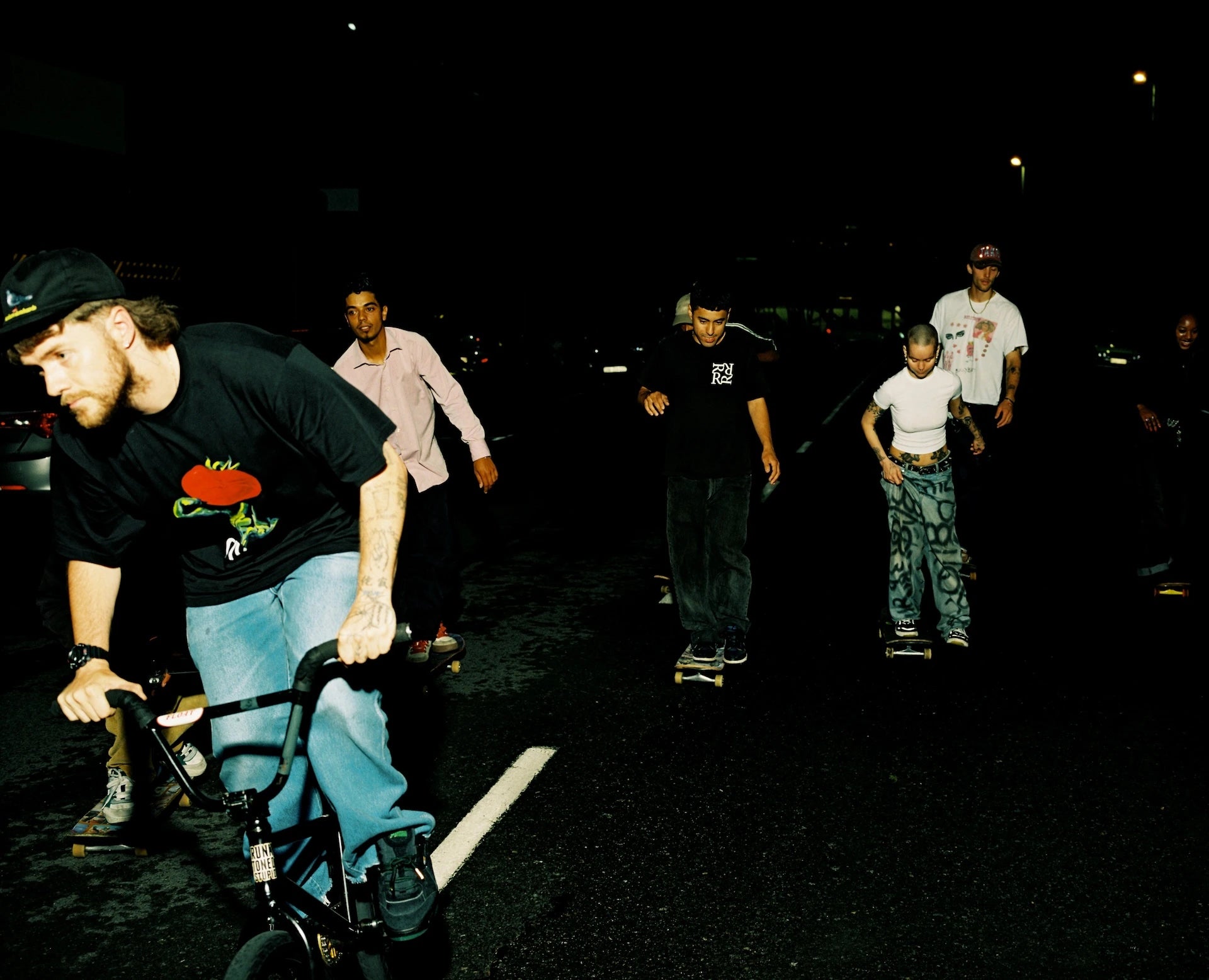 Group of skateboarders on a dark street at night