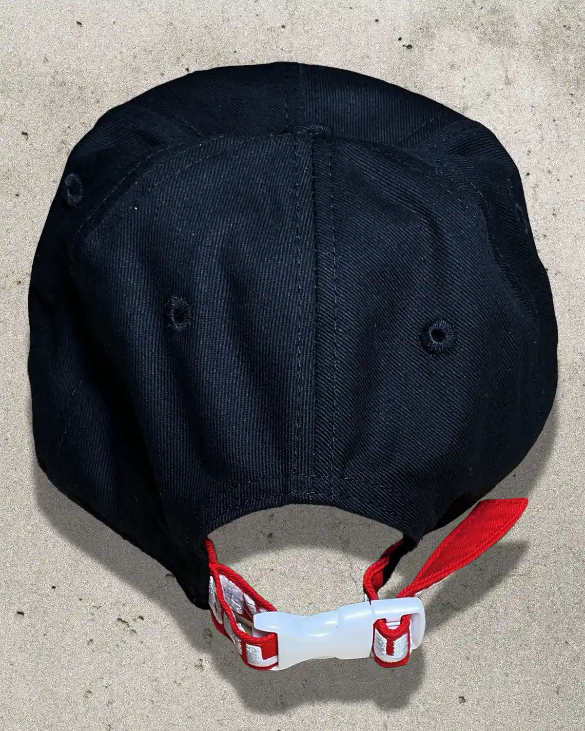 Back view of black Bullyboy cap with signature red strap, white embroidered branding, and white clasp