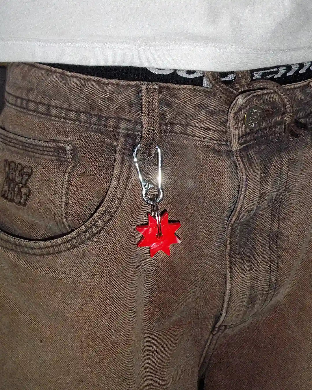 The Bullyboy Mini Star keychain attached to a skater's baggy pants