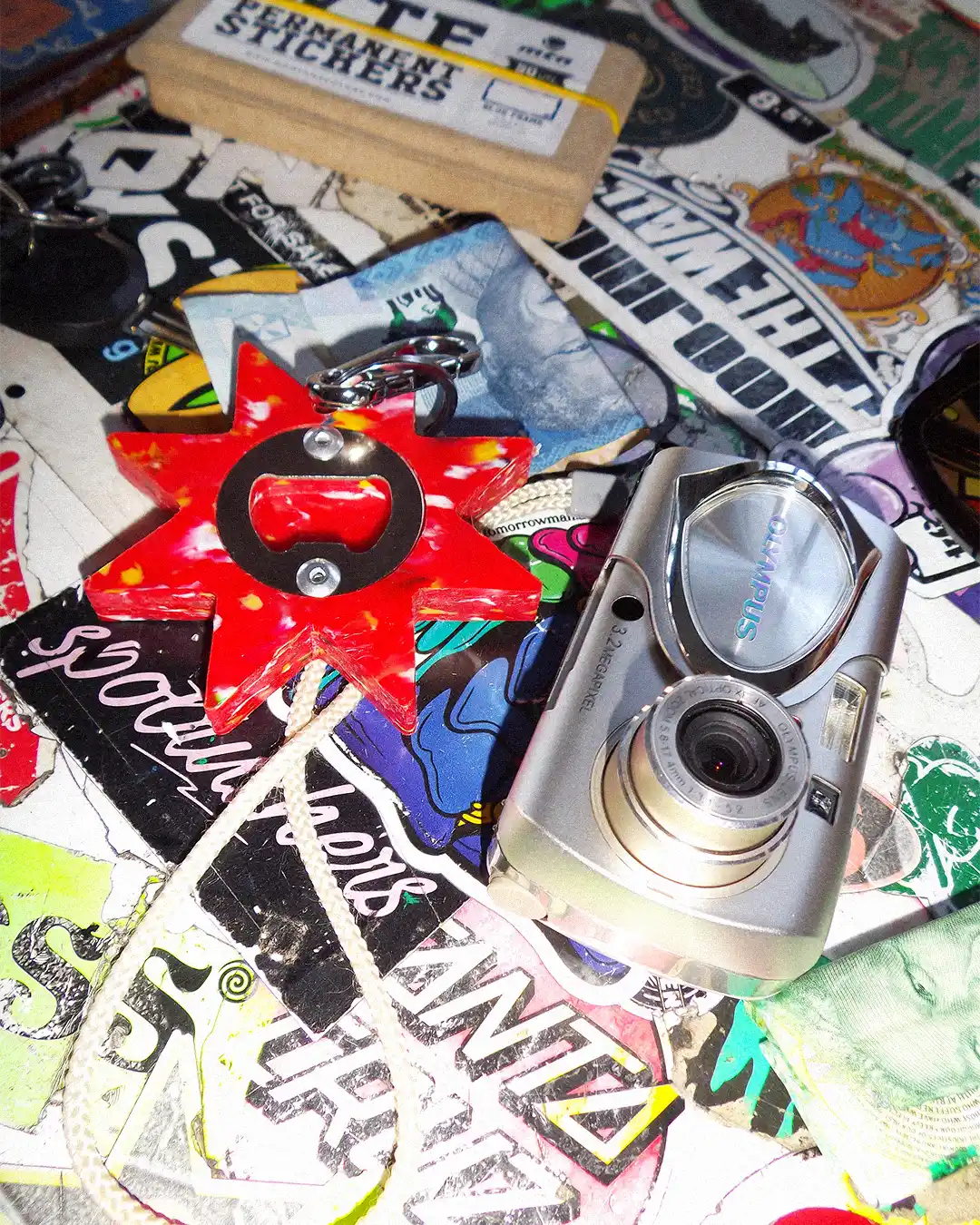 Star Utility Keychain on graffiti table alongside an old Olympus digicam