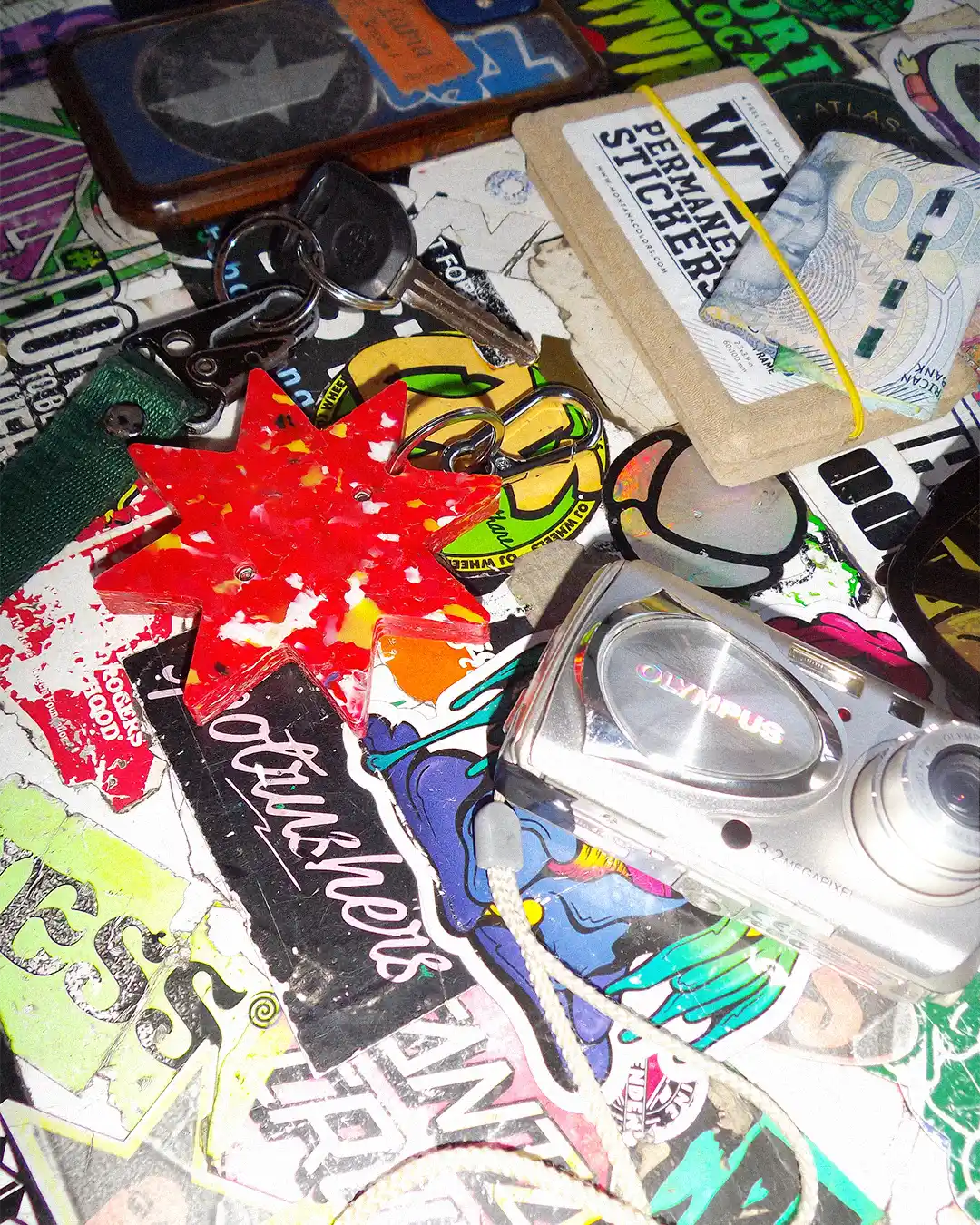 Star Utility Keychain on graffiti table alongside an old Olympus digicam