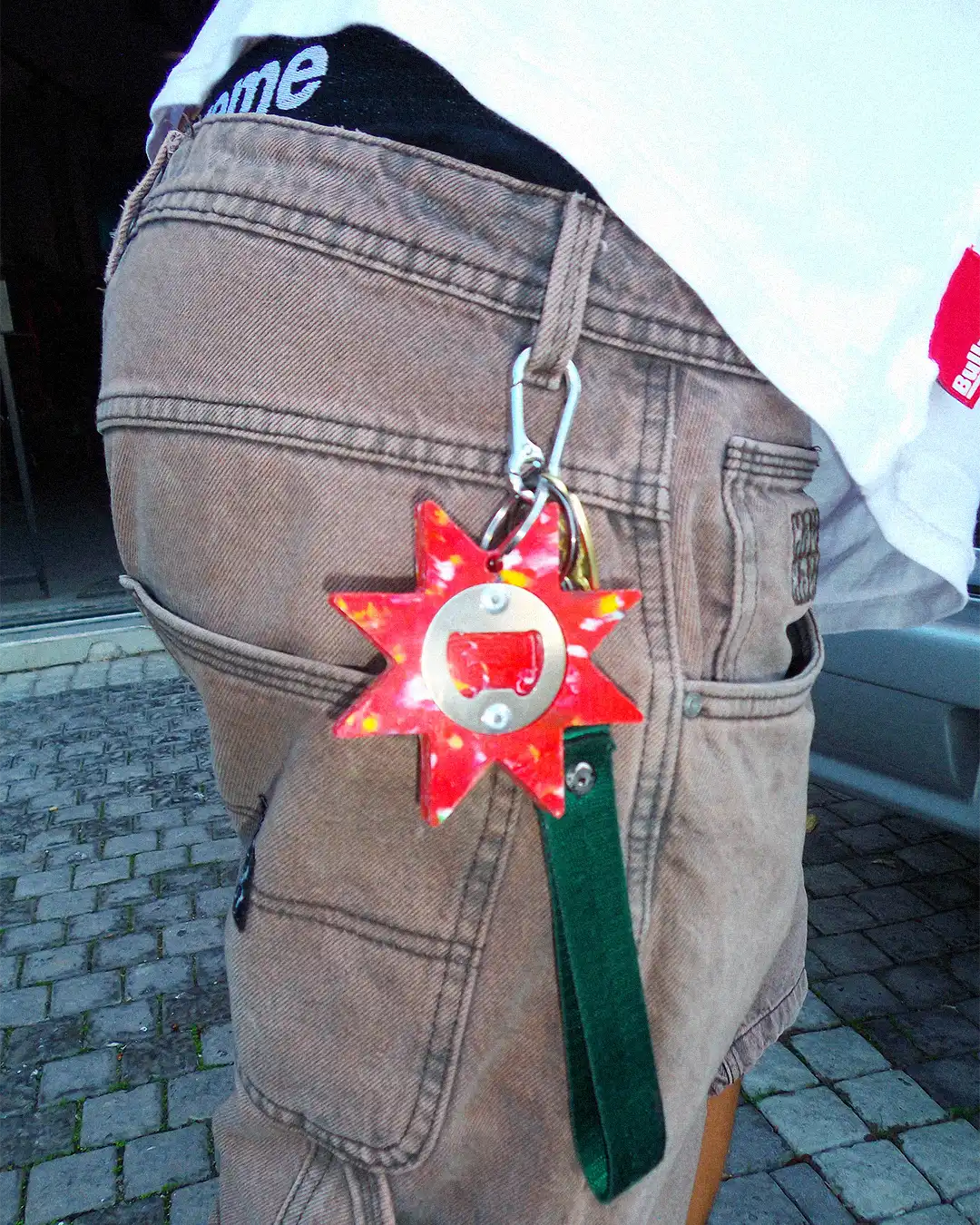 The Bullyboy Star utility Keychain attached with a carabiner to skater's baggy pants