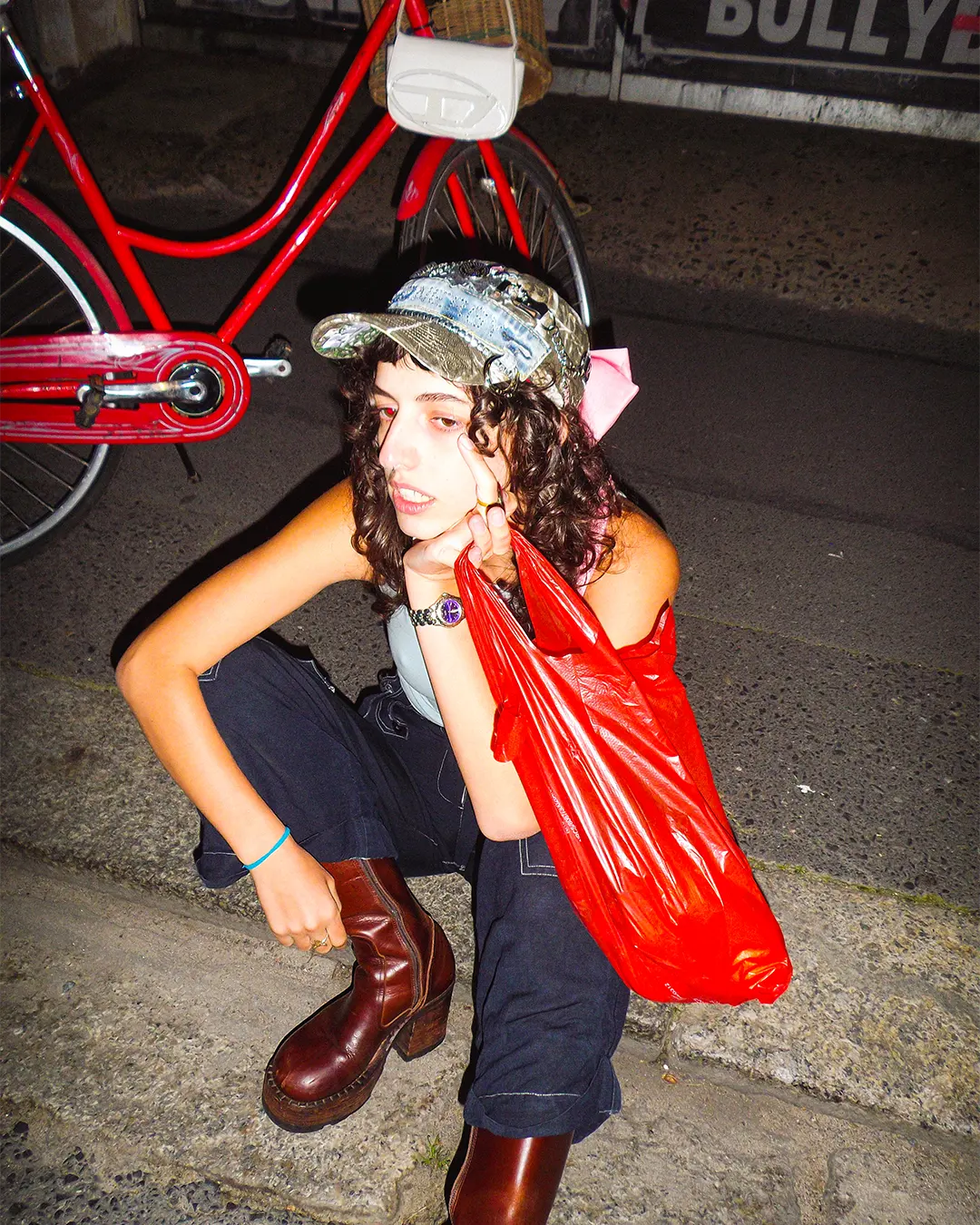 Person sitting on a step with a red bicycle in the background