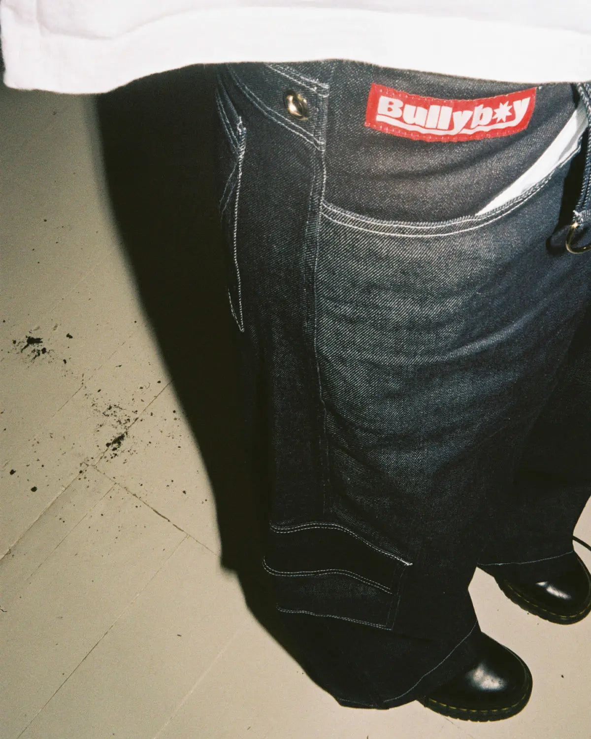 A person in baggy skate pants stands on a floor, showcasing premium streetwear style