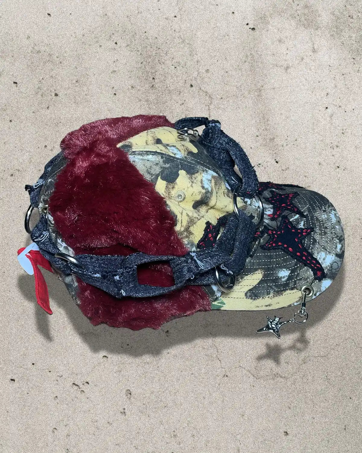 Colorful mask with red and black design on a beige surface