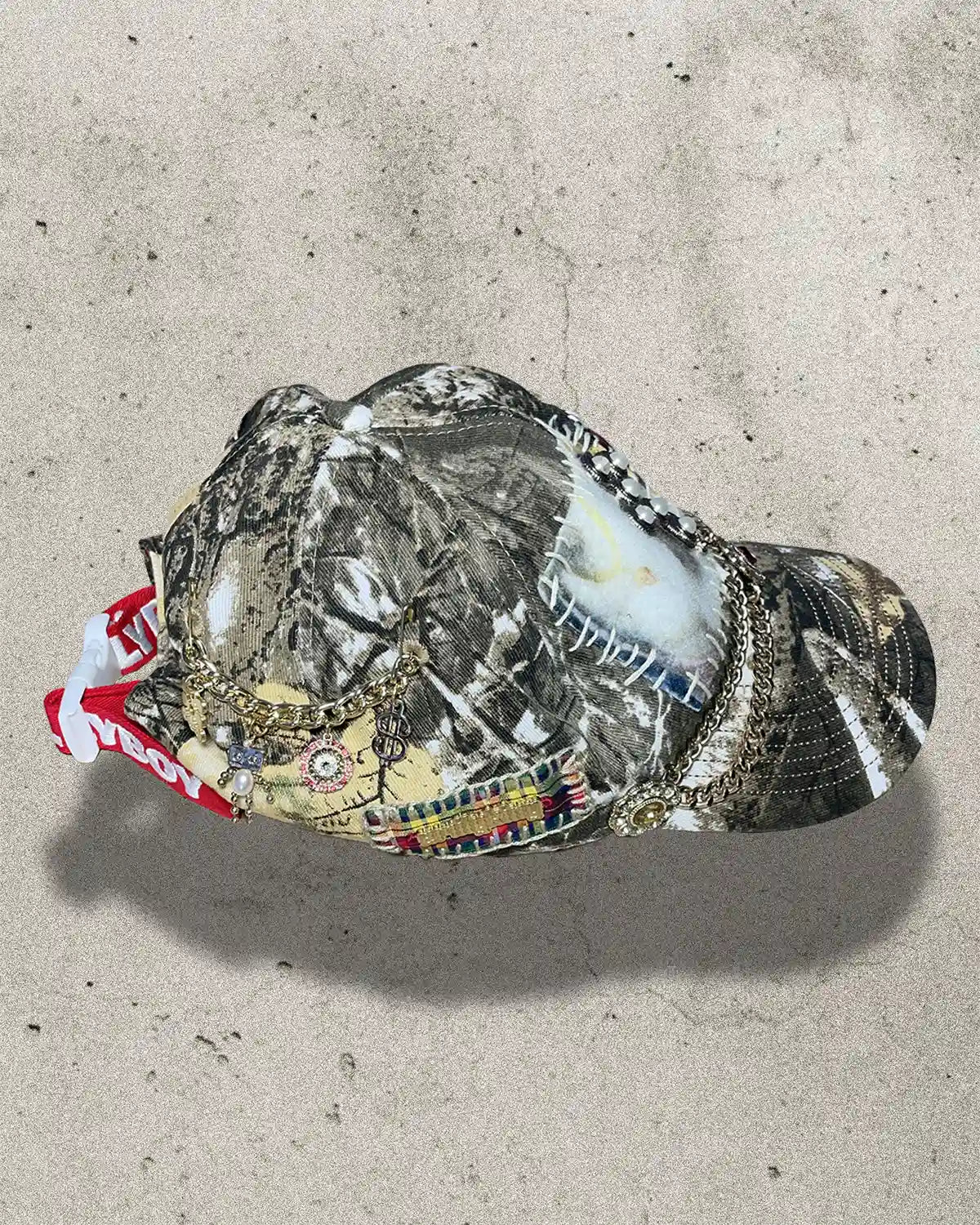 Camouflage-patterned cap with colorful design on a concrete surface