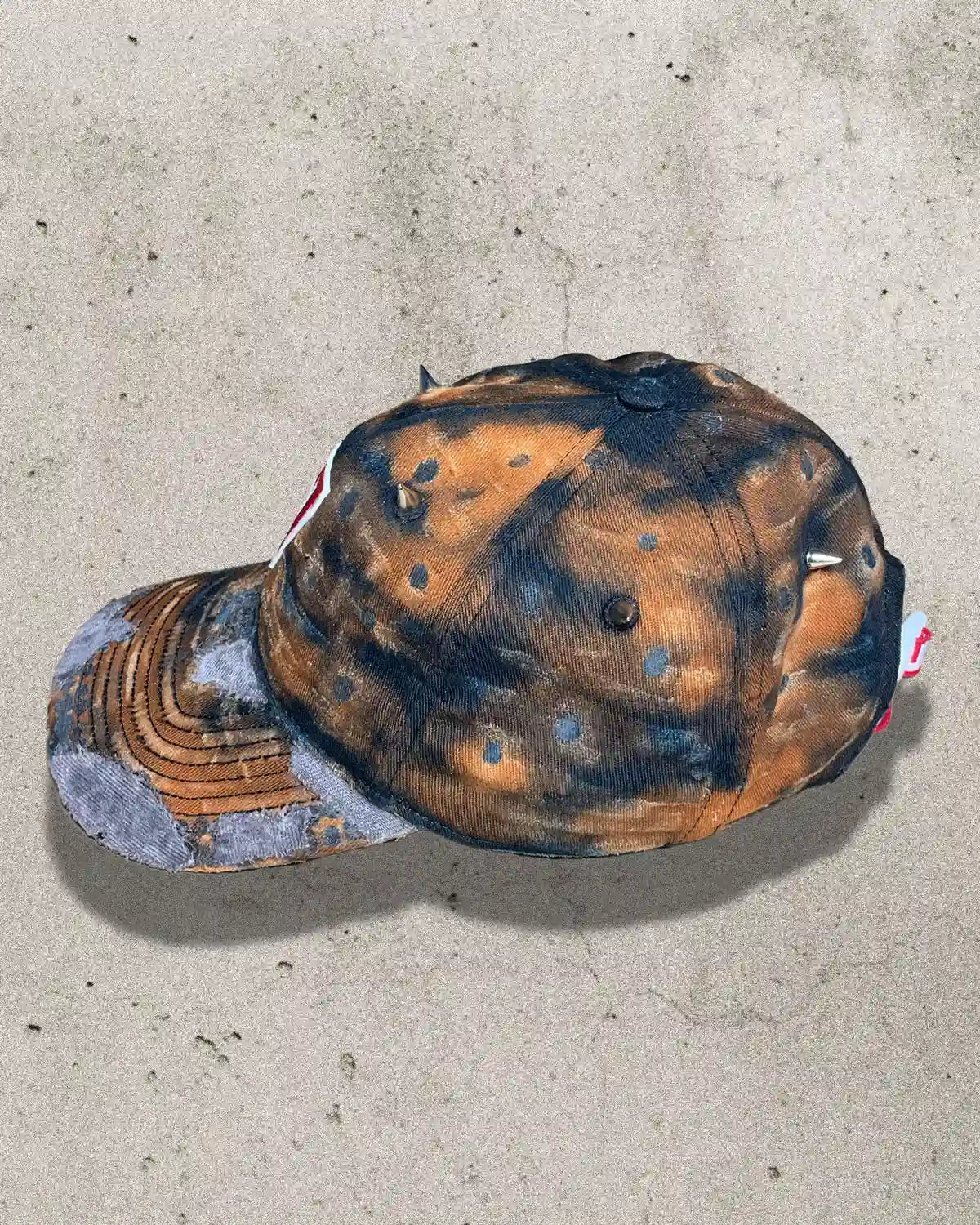 Unique Bullyboy dad cap in rusty orange with metal spikes – side view showcasing streetwear design