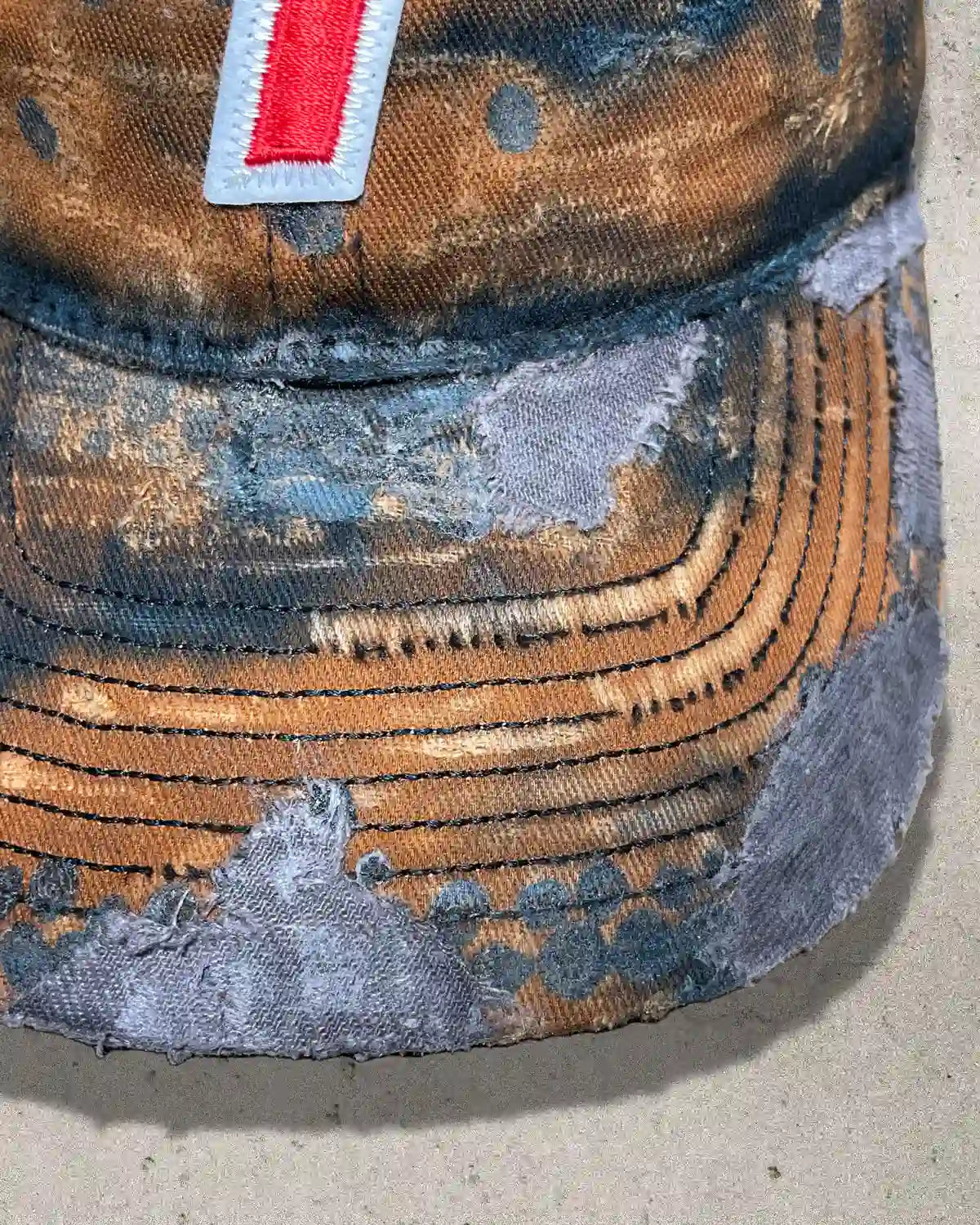 Close-up of silver metal spikes and distressed fabric on the Rust Bucket one of one cap