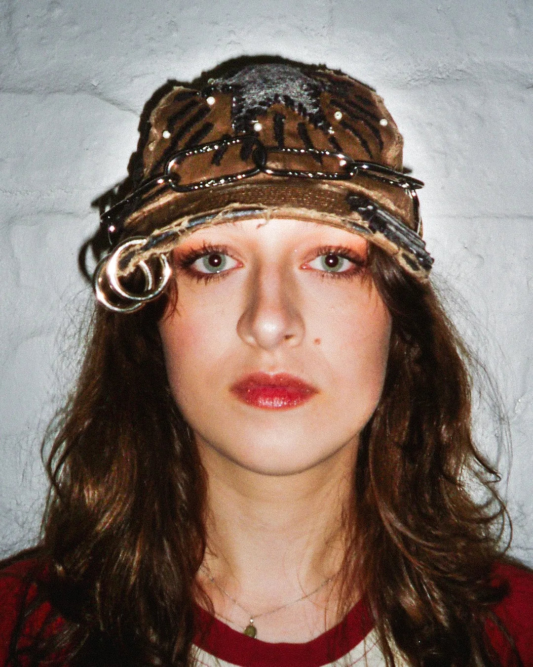 Person wearing a decorative hat against a plain background