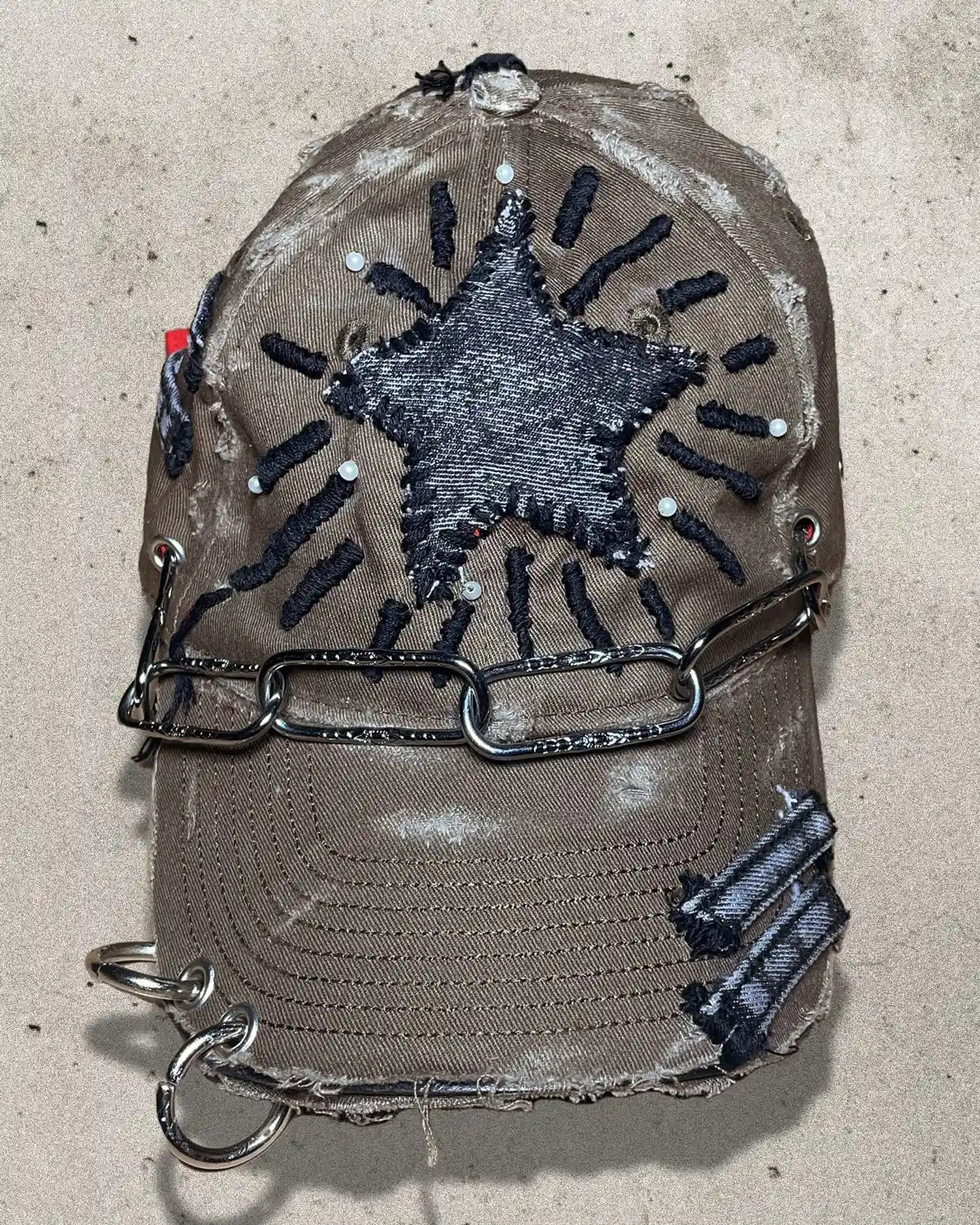 Distressed cap with star design and chain on a concrete surface