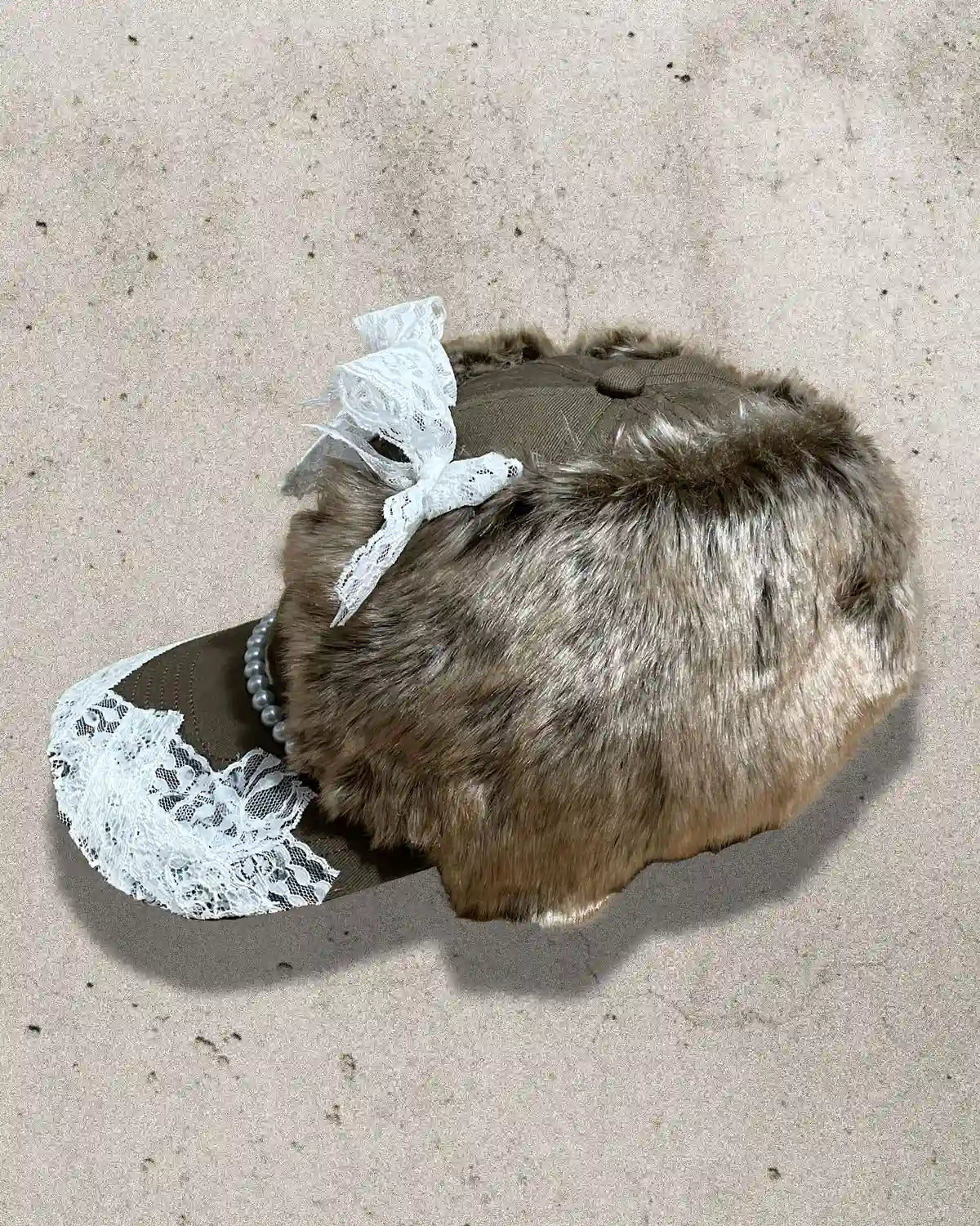 Brown furry cap with pearls, lace, and embroidered number 7 design.
