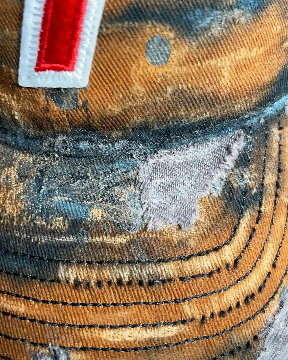 Close-up shot of the Bullyboy one of one Rust Bucket cap with distress marks and orange accents