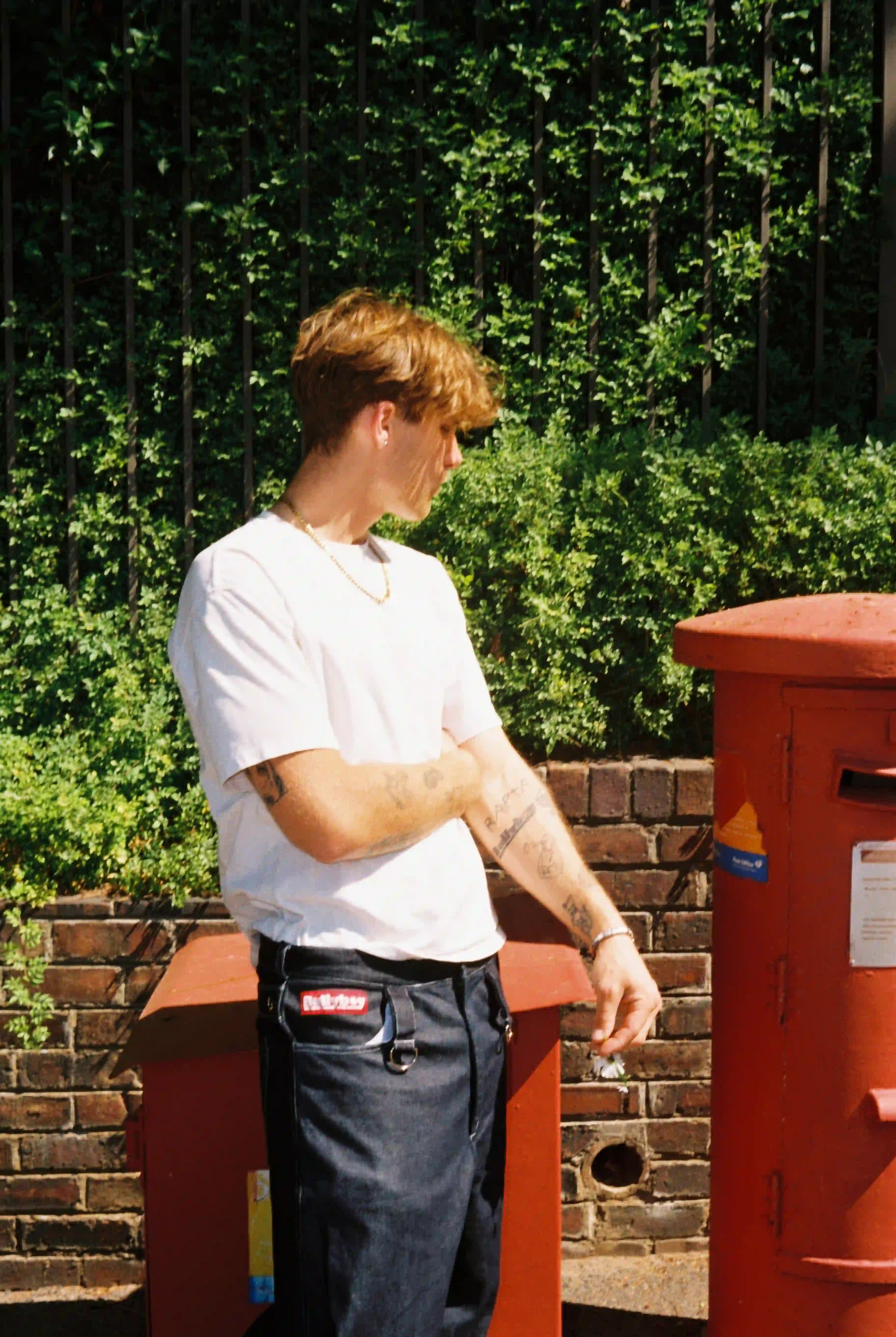 A stylish man poses beside a mailbox, showcasing Bullyboy premium streetwear in vibrant Cape Town.