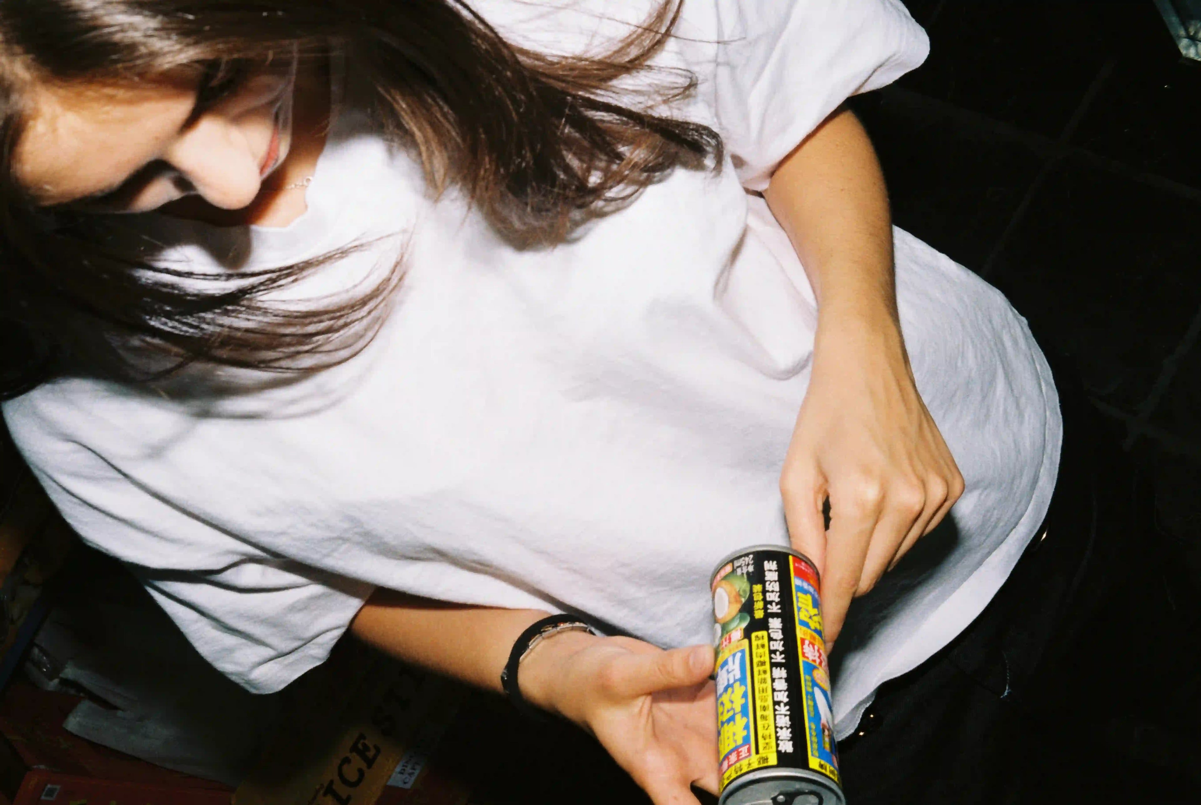 A stylish woman holds a can, embodying the essence of Bullyboy premium streetwear in vibrant Cape Town.