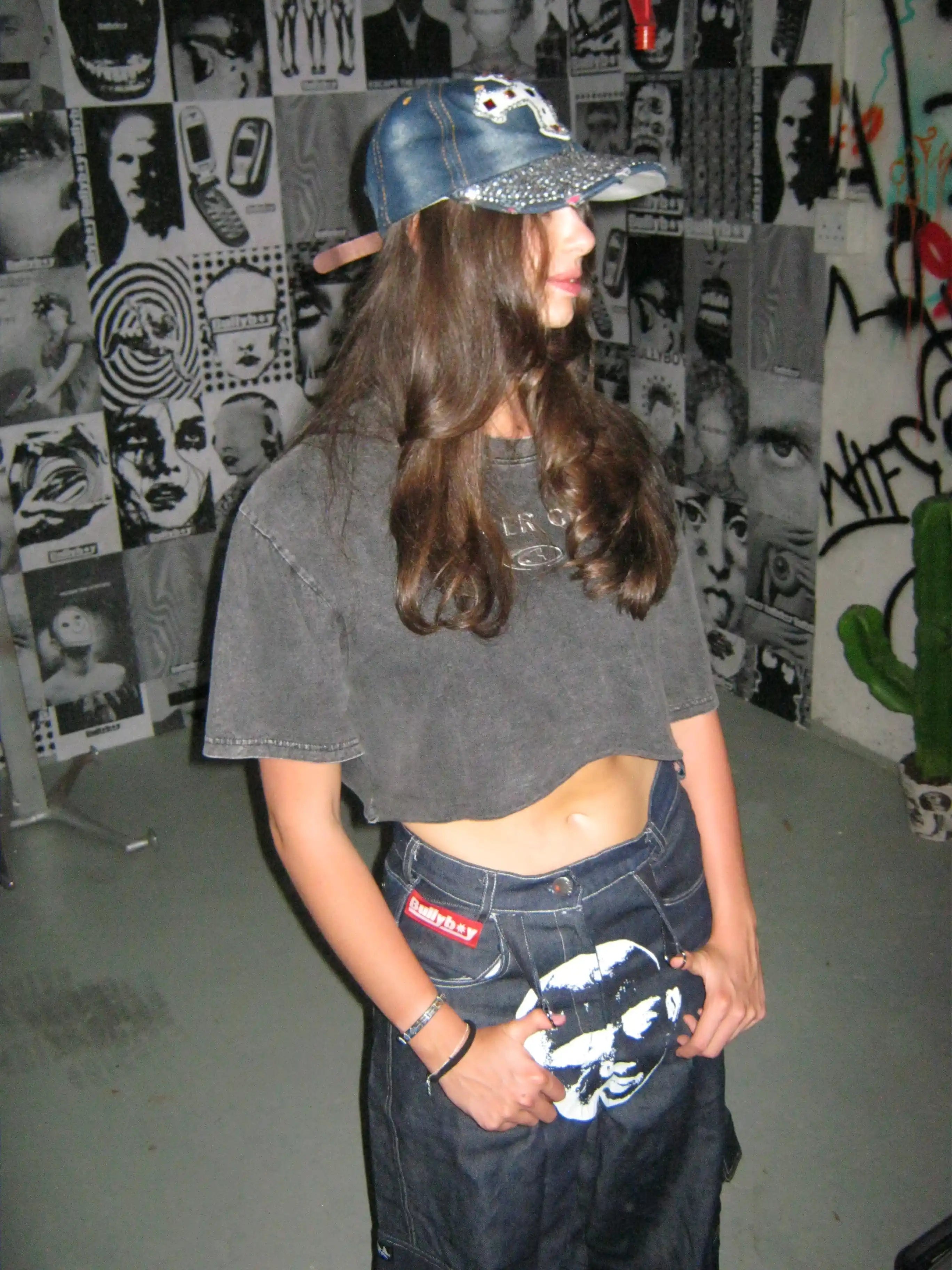 A stylish woman in a hat and baggy jeans, showcasing ethically sourced South African streetwear by Bullyboy.