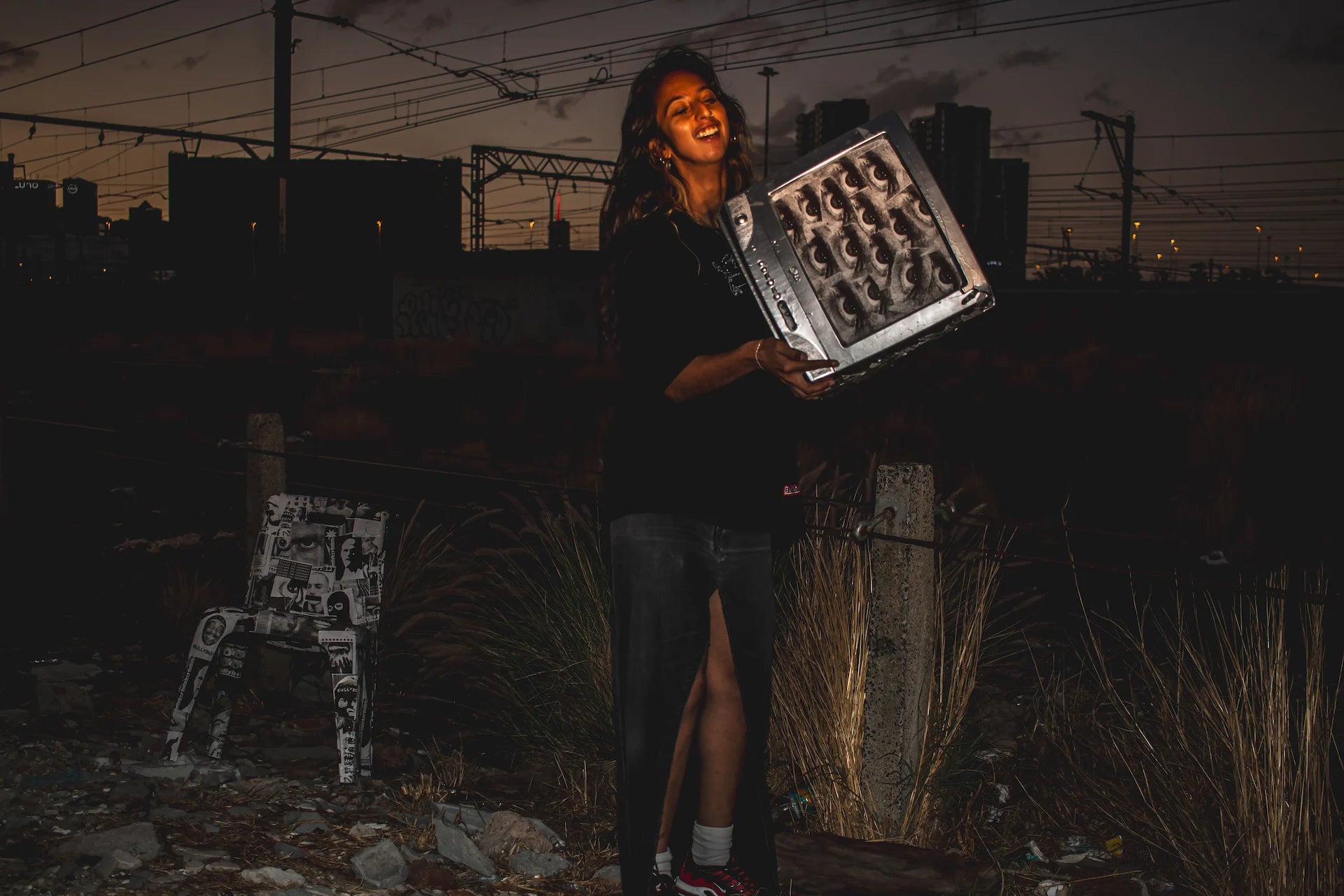 A woman in stylish streetwear holds a TV, showcasing Bullyboy's South African fashion vibe