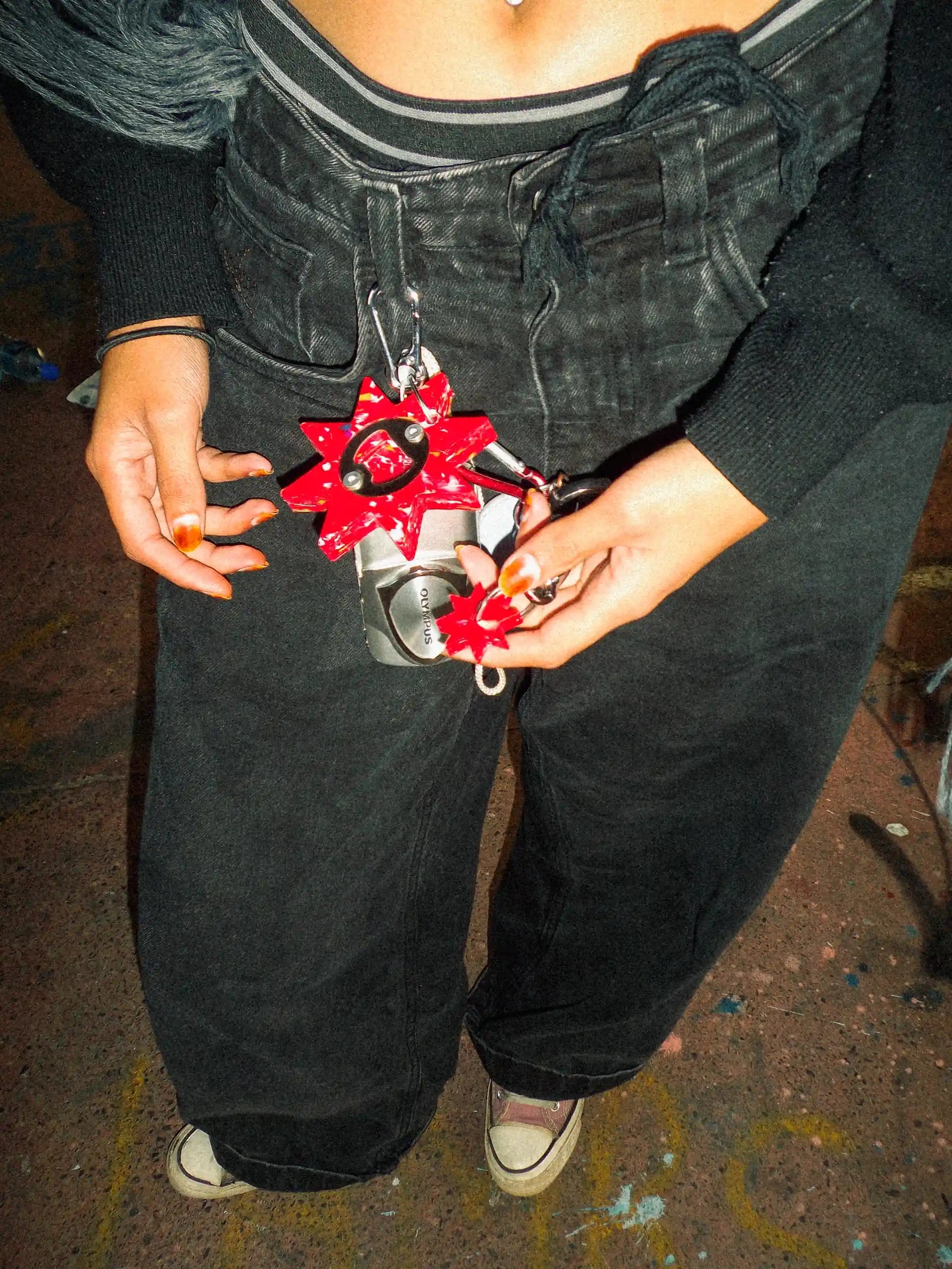 Person holding a red and silver object with star-shaped designs on a dark background