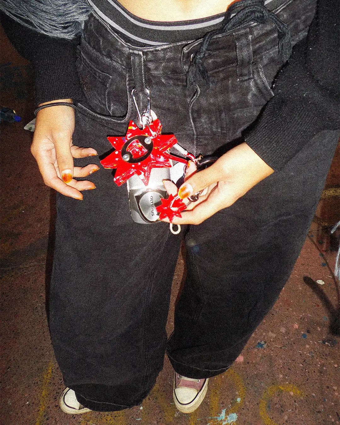 Person holding a red and silver object with a star design on a dark background
