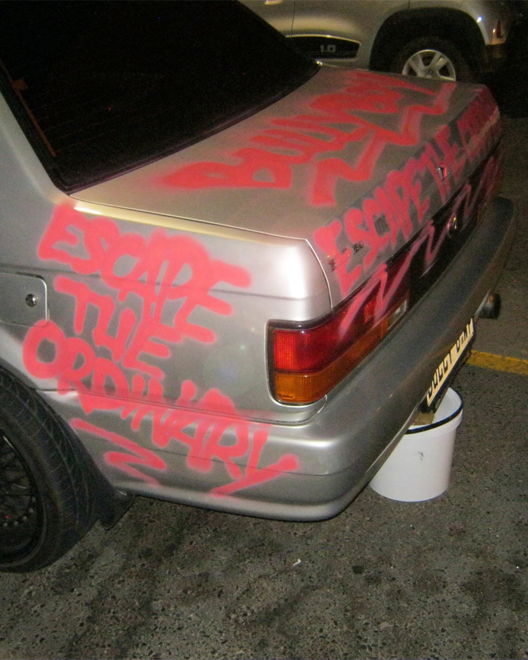 Car with red graffiti on a concrete surface