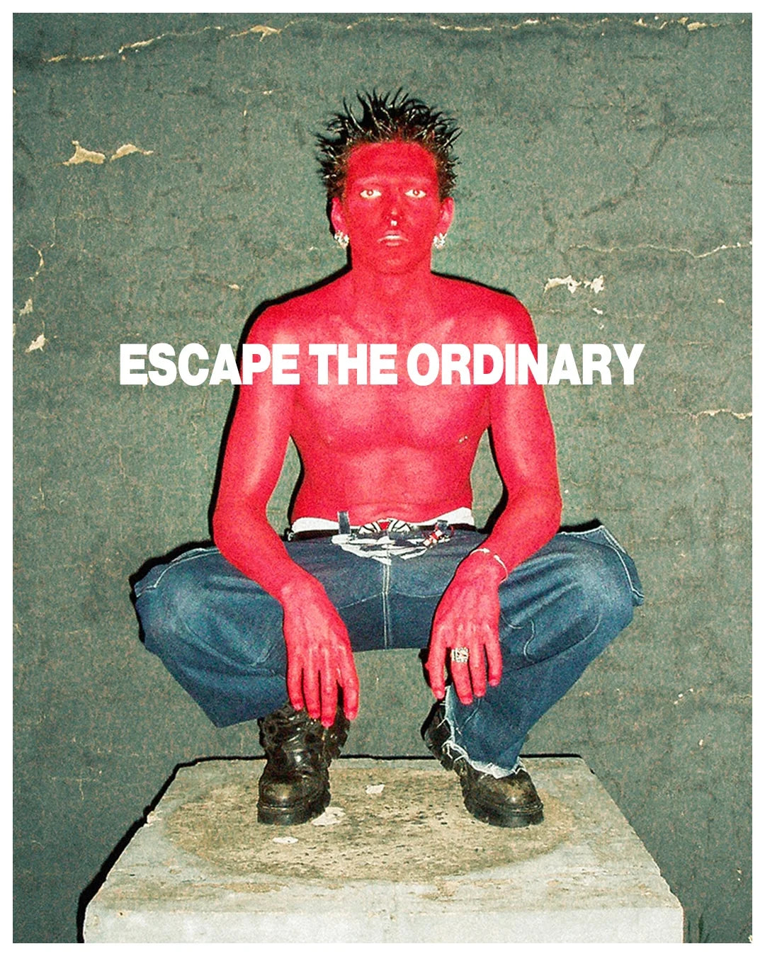 Person with red skin crouching on a stone block against a textured wall with 'Escape the Ordinary' text.