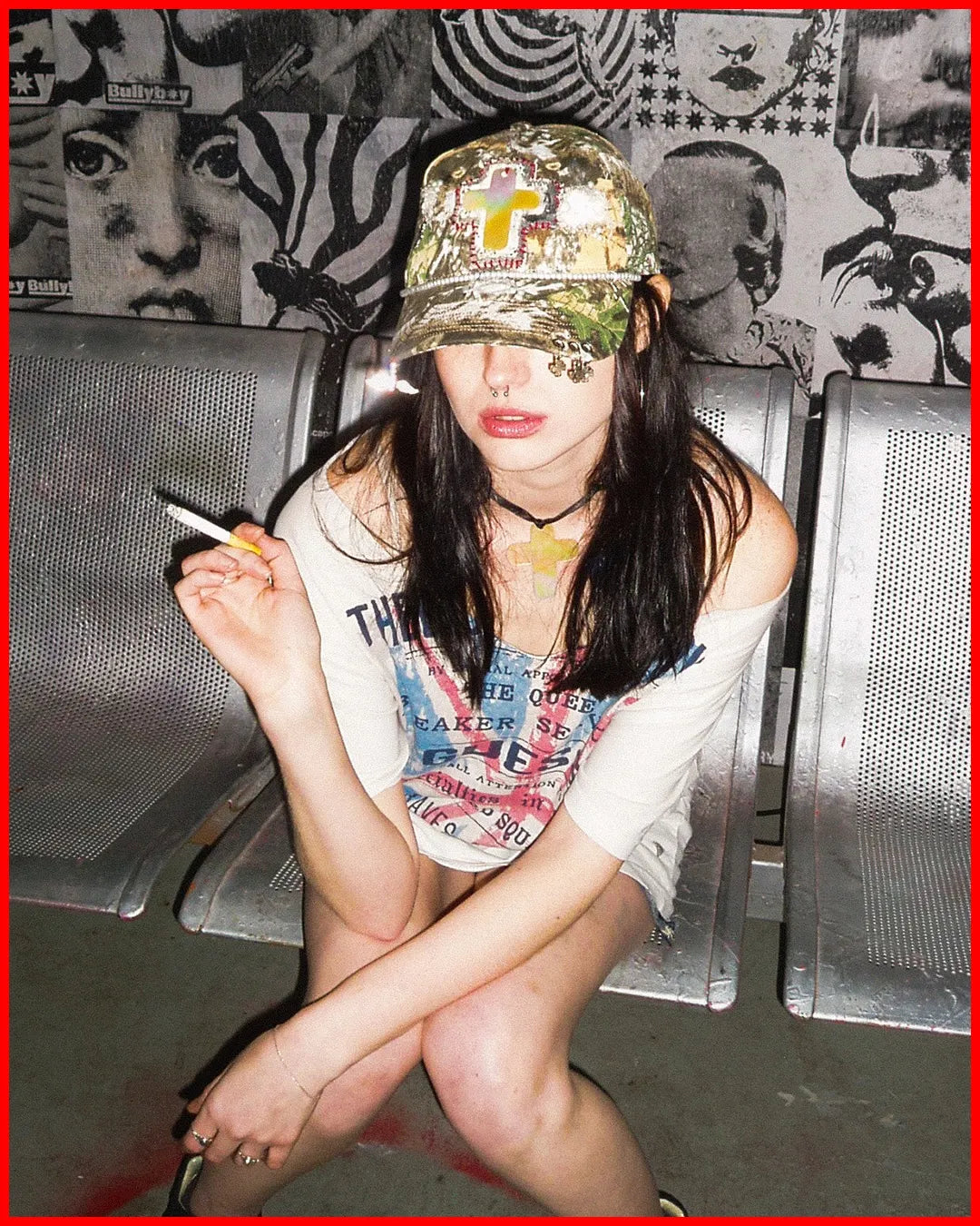 Person sitting on a bench wearing a gold cap and colorful shirt with text.