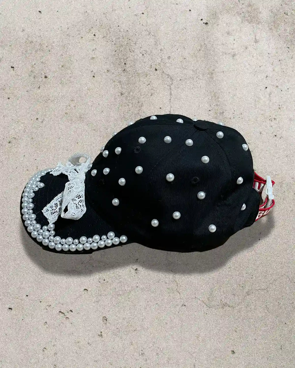 Handcrafted cap featuring contrast of black fabric and white detailing.