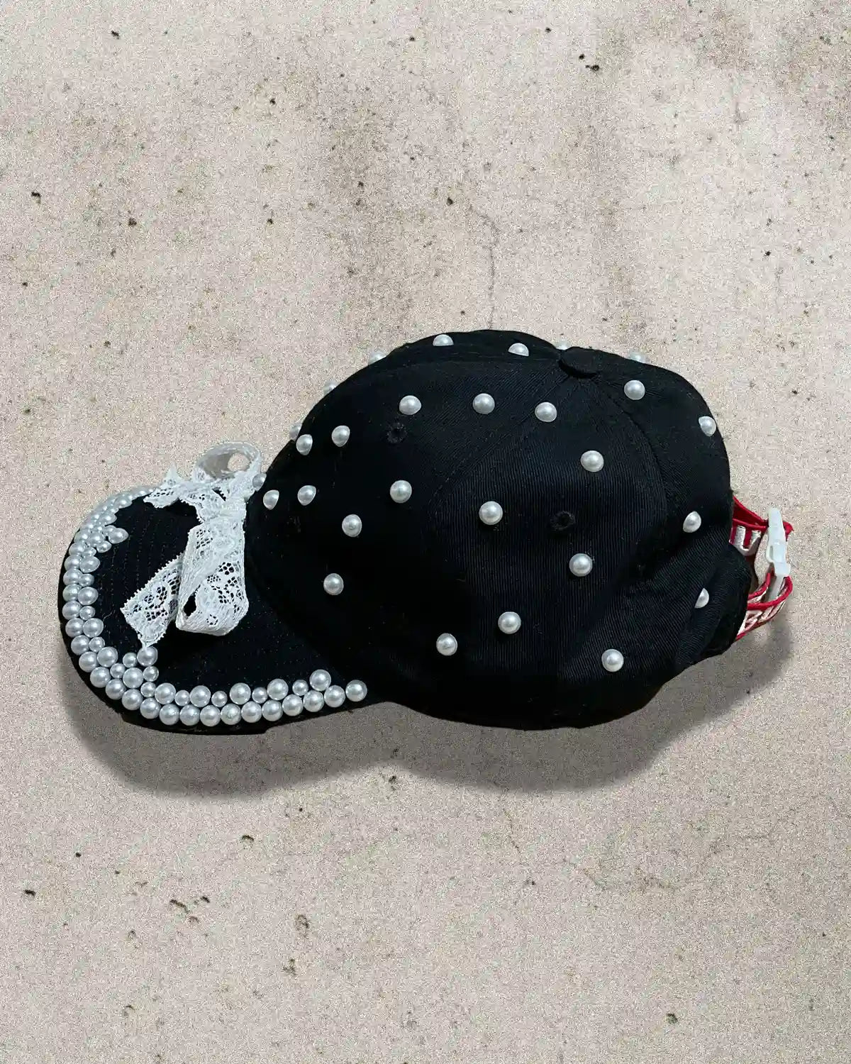 Handcrafted cap featuring contrast of black fabric and white detailing.