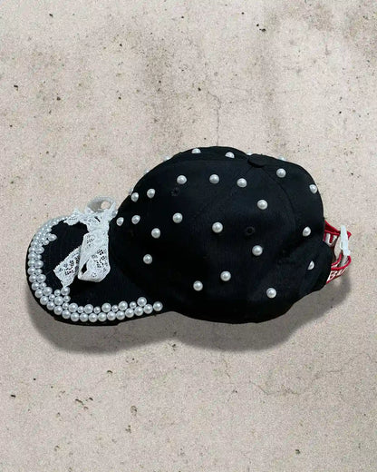 Handcrafted cap featuring contrast of black fabric and white detailing.