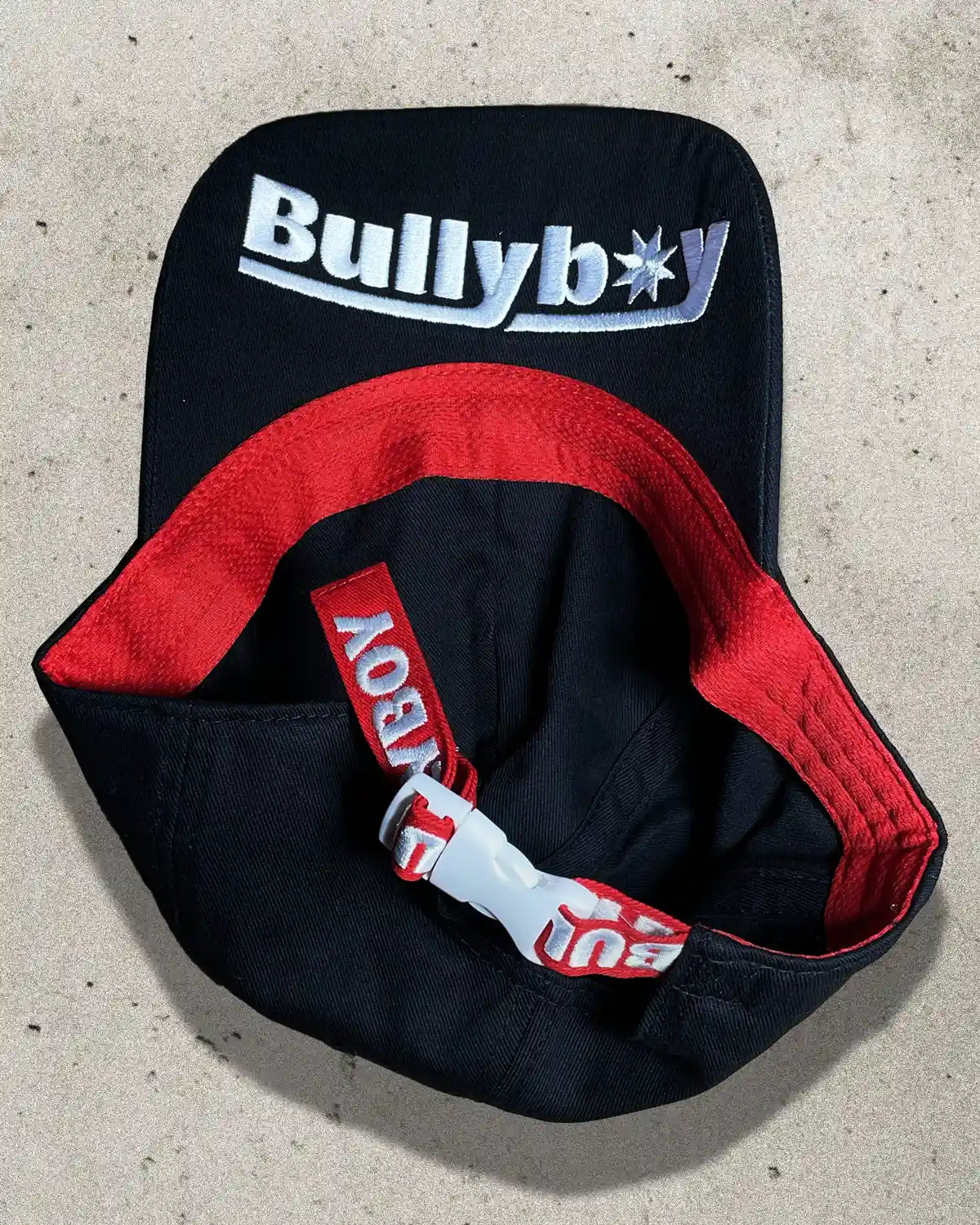 Detail shot of black Bullyboy cap showing underside logo embroidery and durable cotton weave