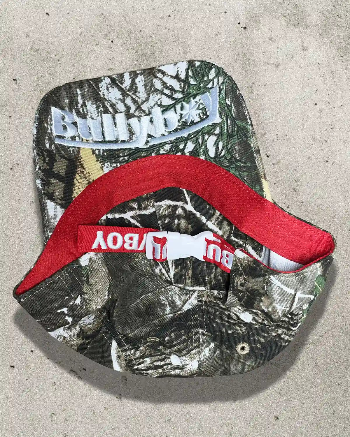 Close-up of camo Bullyboy cap showing embroidered Bullyboy logo under the peak and cotton fabric texture