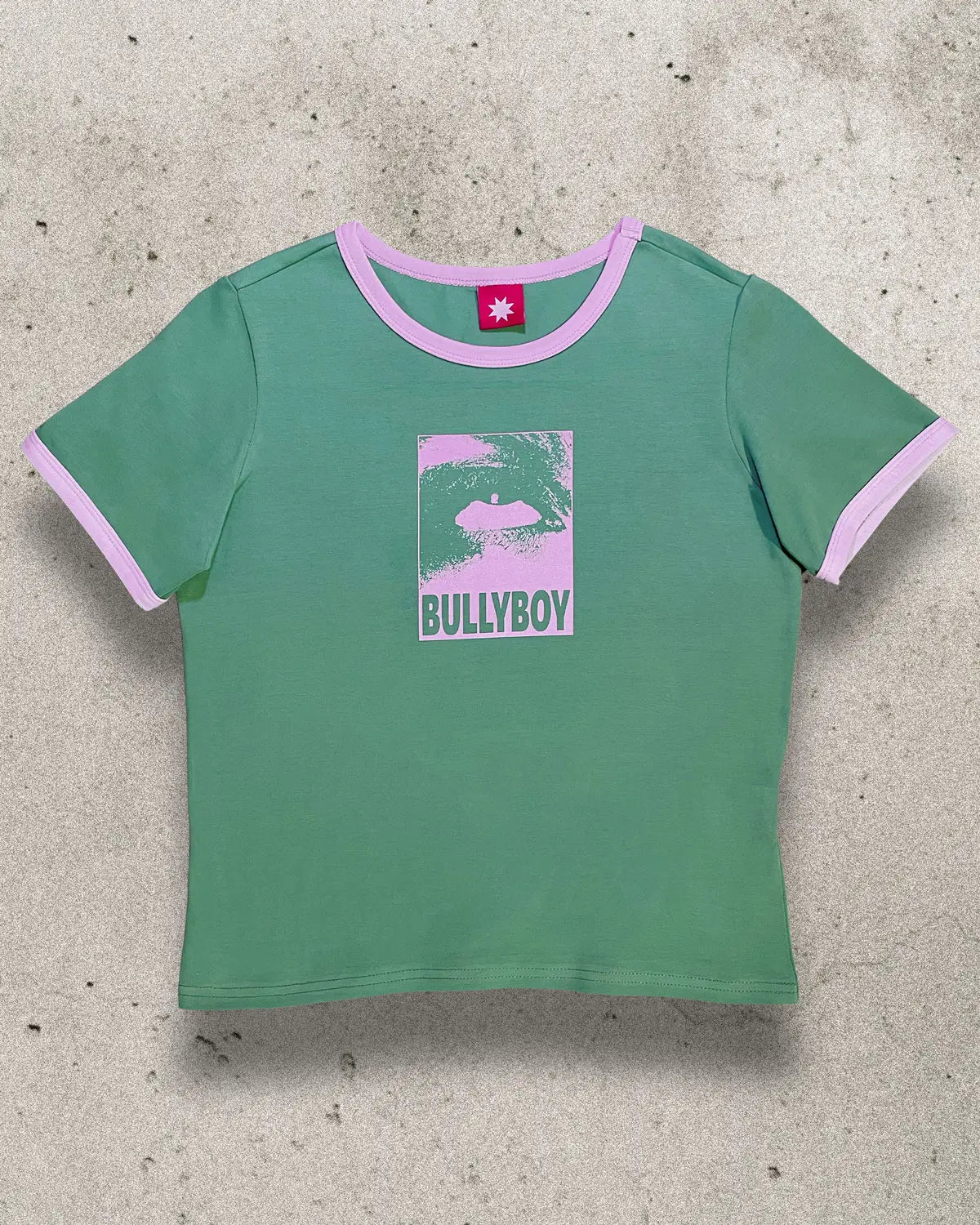 Green 100% lightweight cotton fitted top with a pink eye design on the front.
