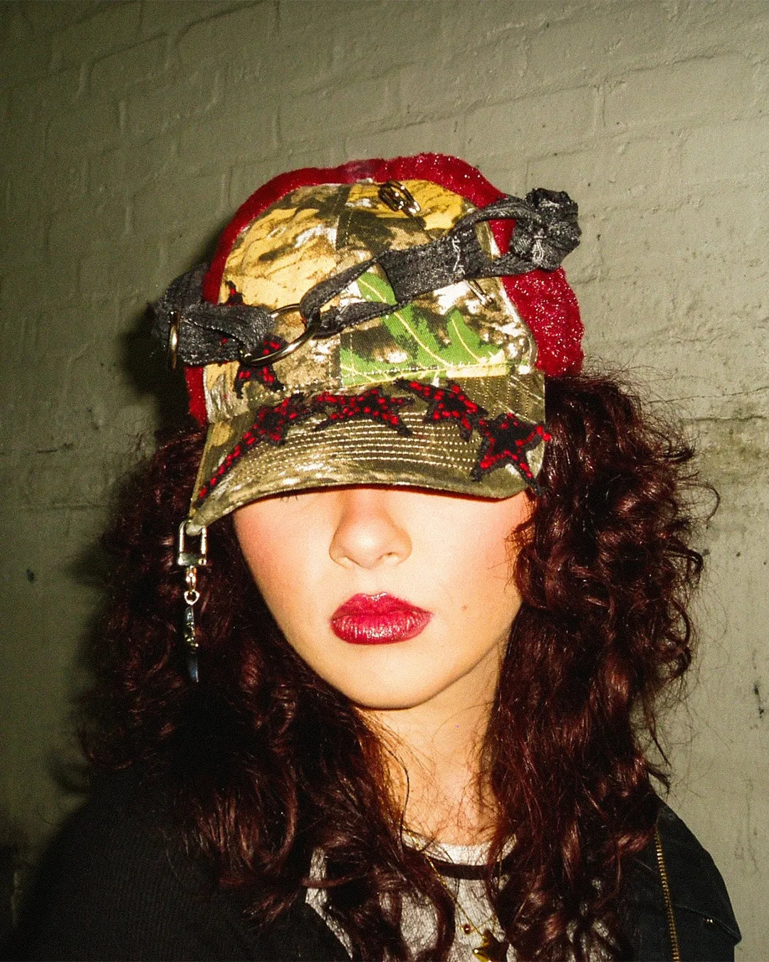 Person wearing a colorful, patterned hat against a plain background