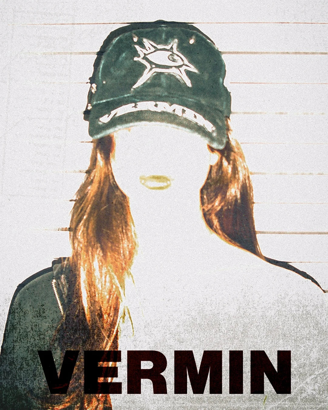 Person wearing a cap with a logo and 'VERMIN' text on a textured background