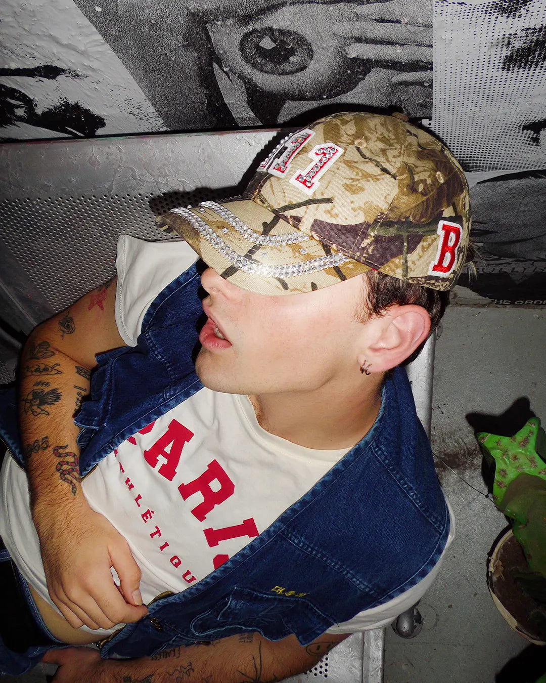 person lying on a metal bench during a night time editorial shoot for the new Bullyboy one of one caps