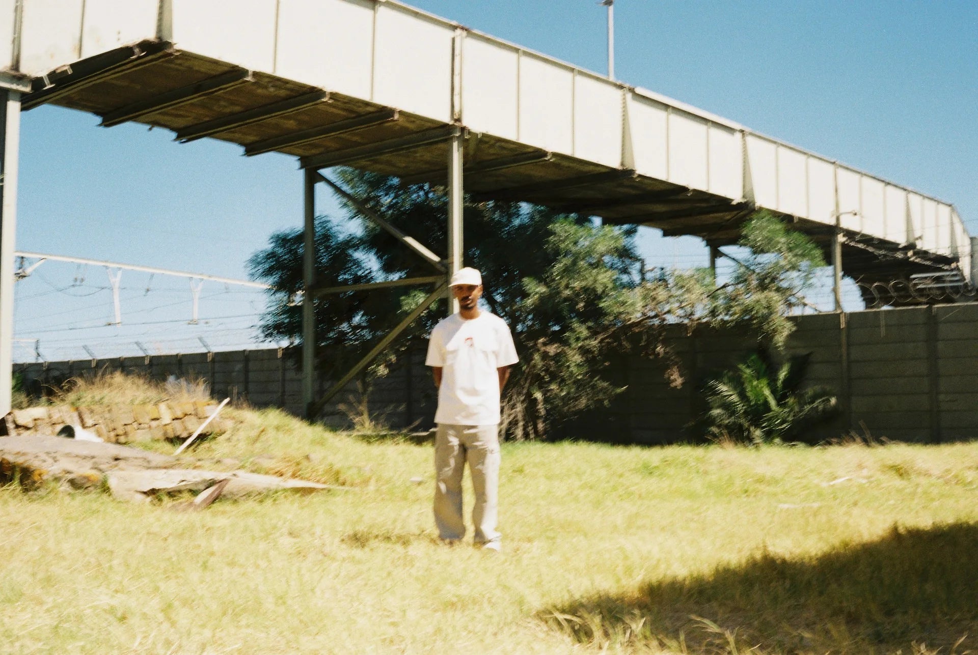 A man in a field with a skateboard highlights Bullyboy's debut premium streetwear collection, celebrating South African fashion