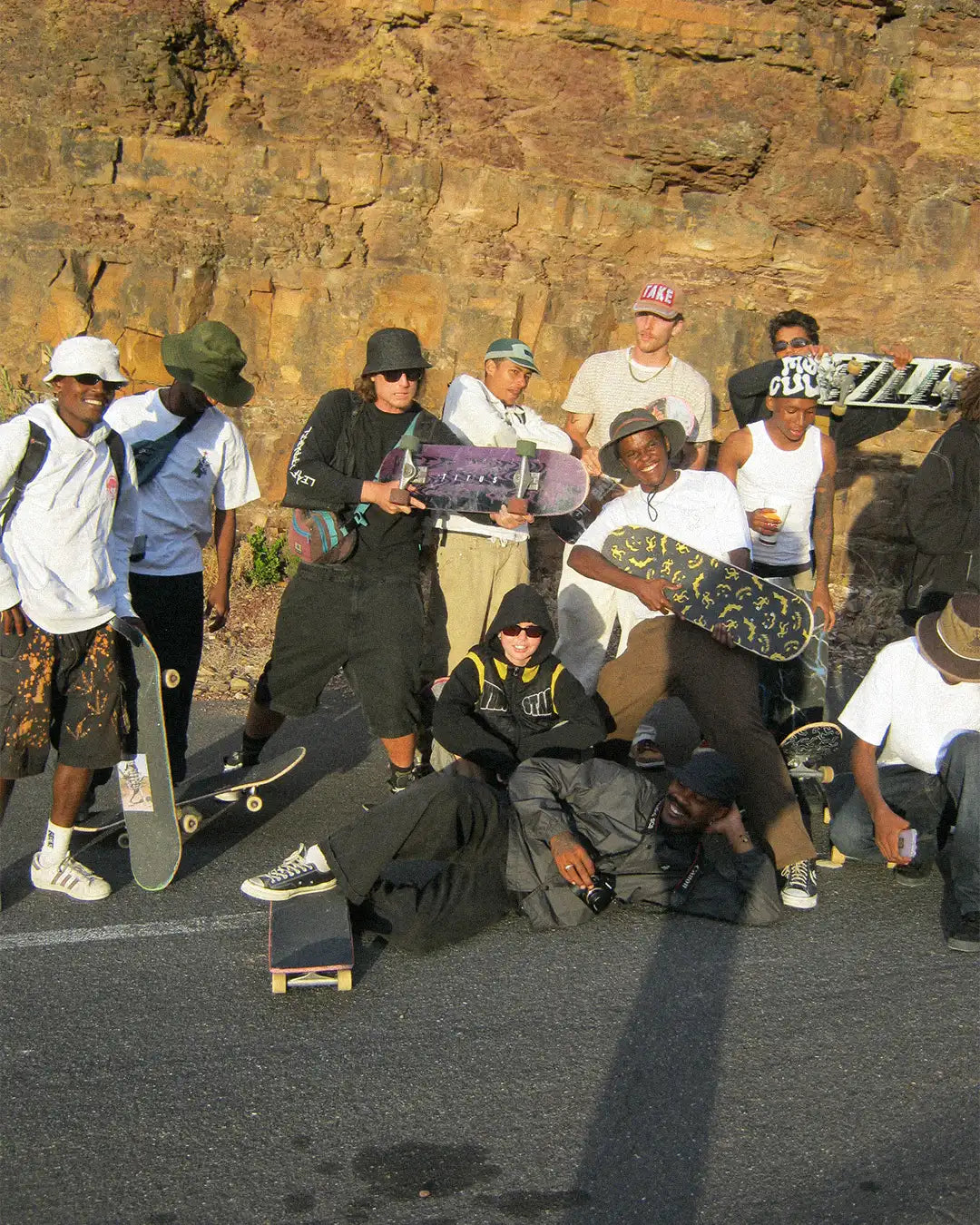 A group of stylish individuals poses together, showcasing camaraderie in the Skating Is Risky x Bullyboy skate edit collaboration.