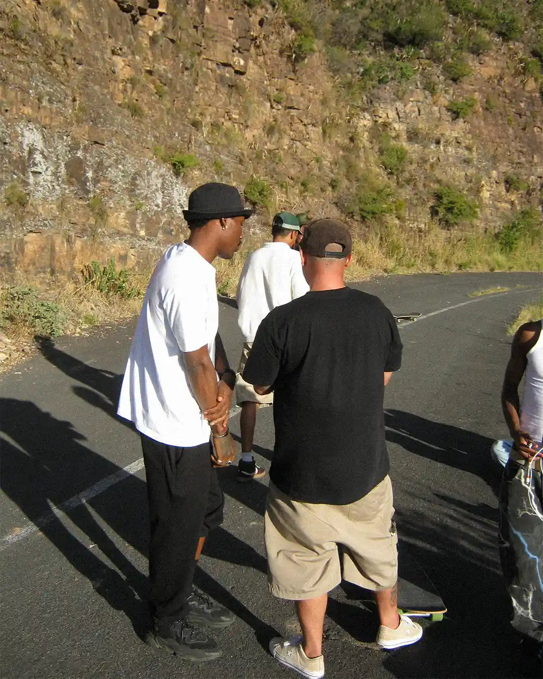A group of skaters poses confidently on a road, showcasing the Skating Is Risky x Bullyboy skate edit collaboration