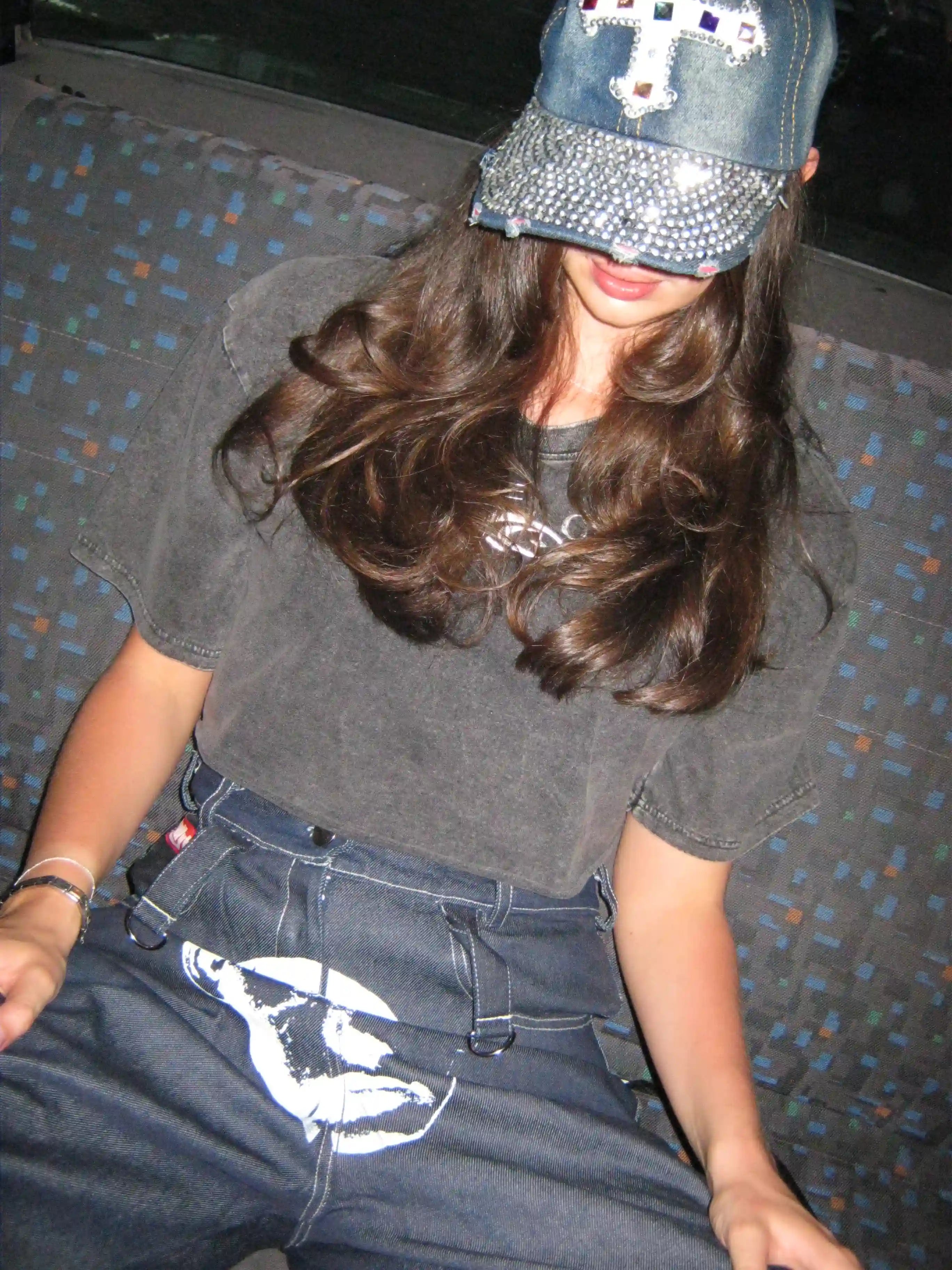 A stylish woman in a hat and baggy jeans, showcasing ethically sourced South African streetwear by Bullyboy.