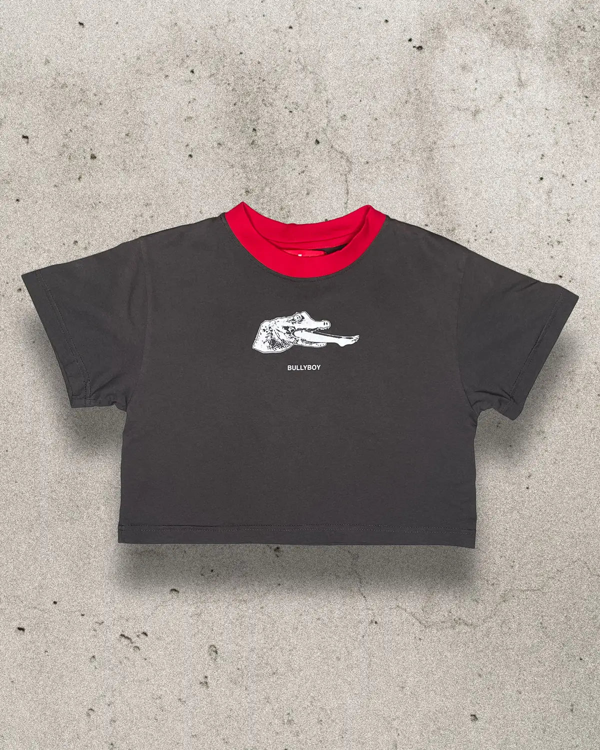 Black 100% lightweight cotton female crop top with a crocodile graphic on the front and a red neckline.