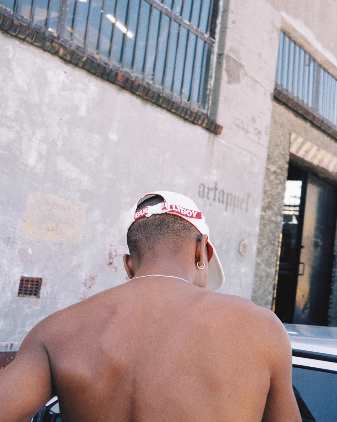 A man in a white Bullyboy cap, showcasing premium South African streetwear style